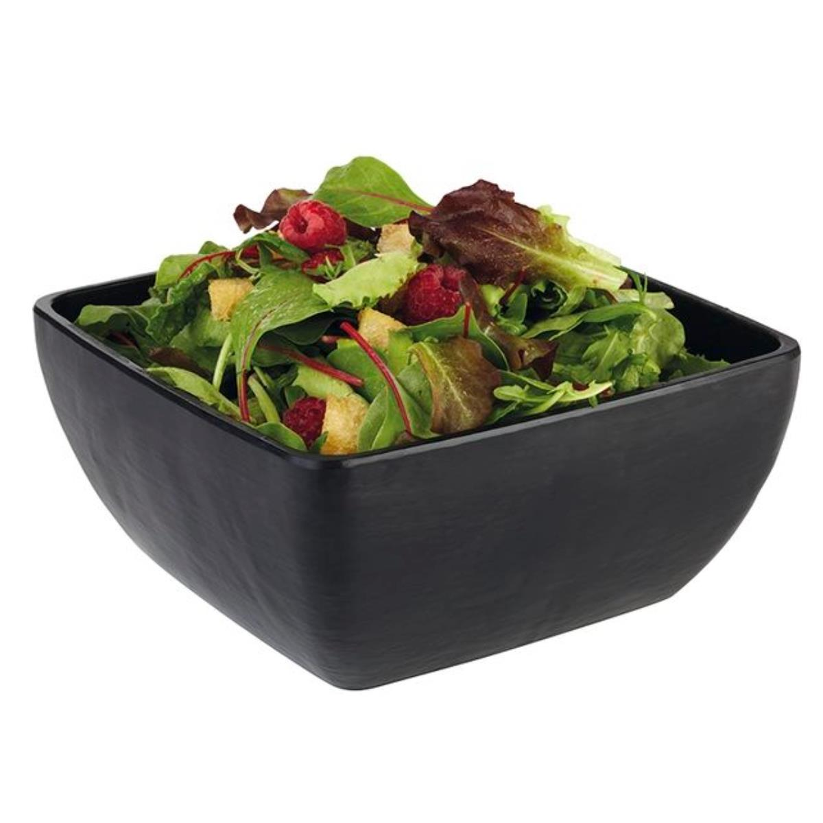 Eine schwarze, quadratische Schüssel gefüllt mit Salat und Himbeeren.