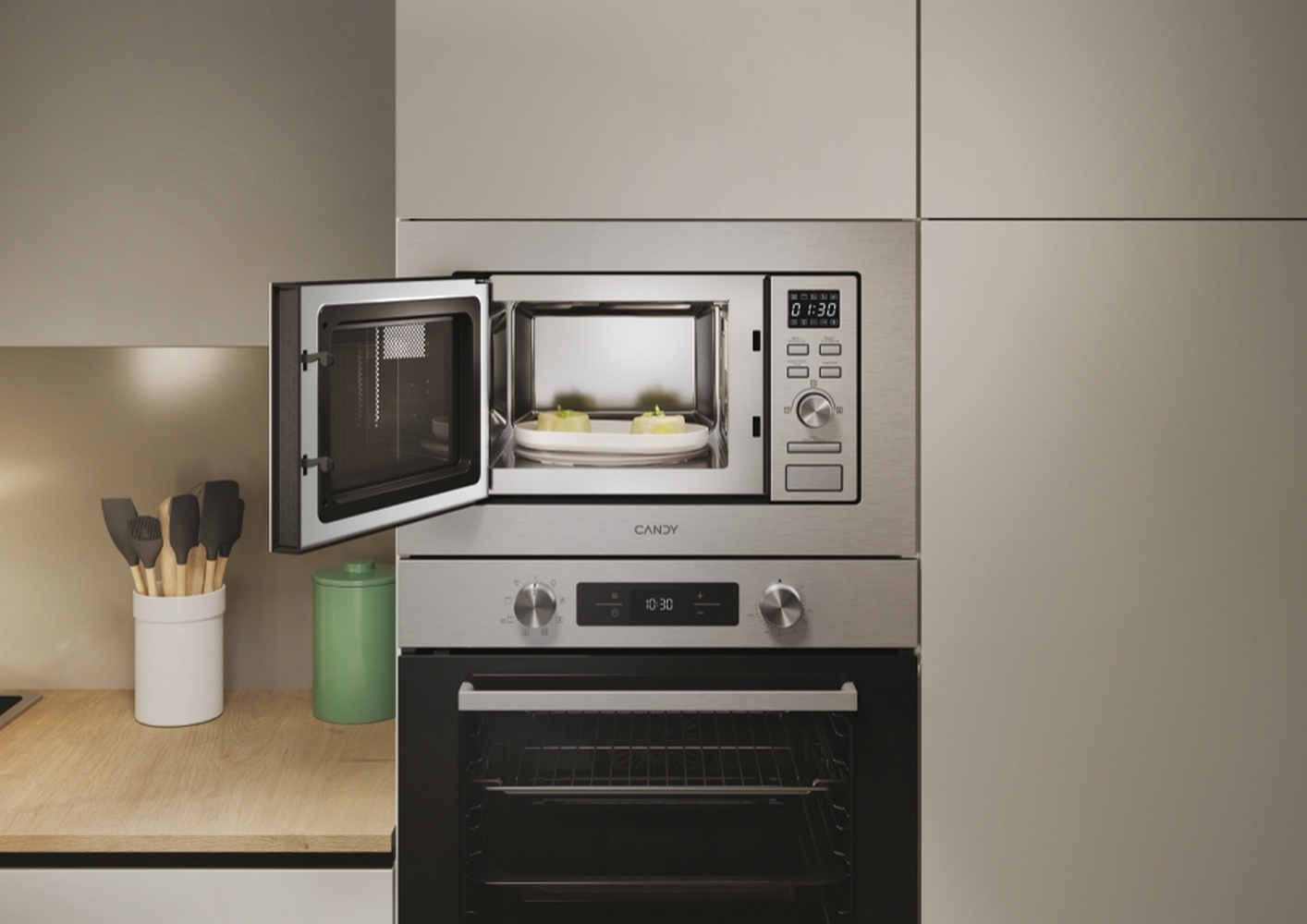 Kuchenka mikrofalowa wbudowana w szafkę kuchenną, otwarte drzwi, z naczyniami w środku.