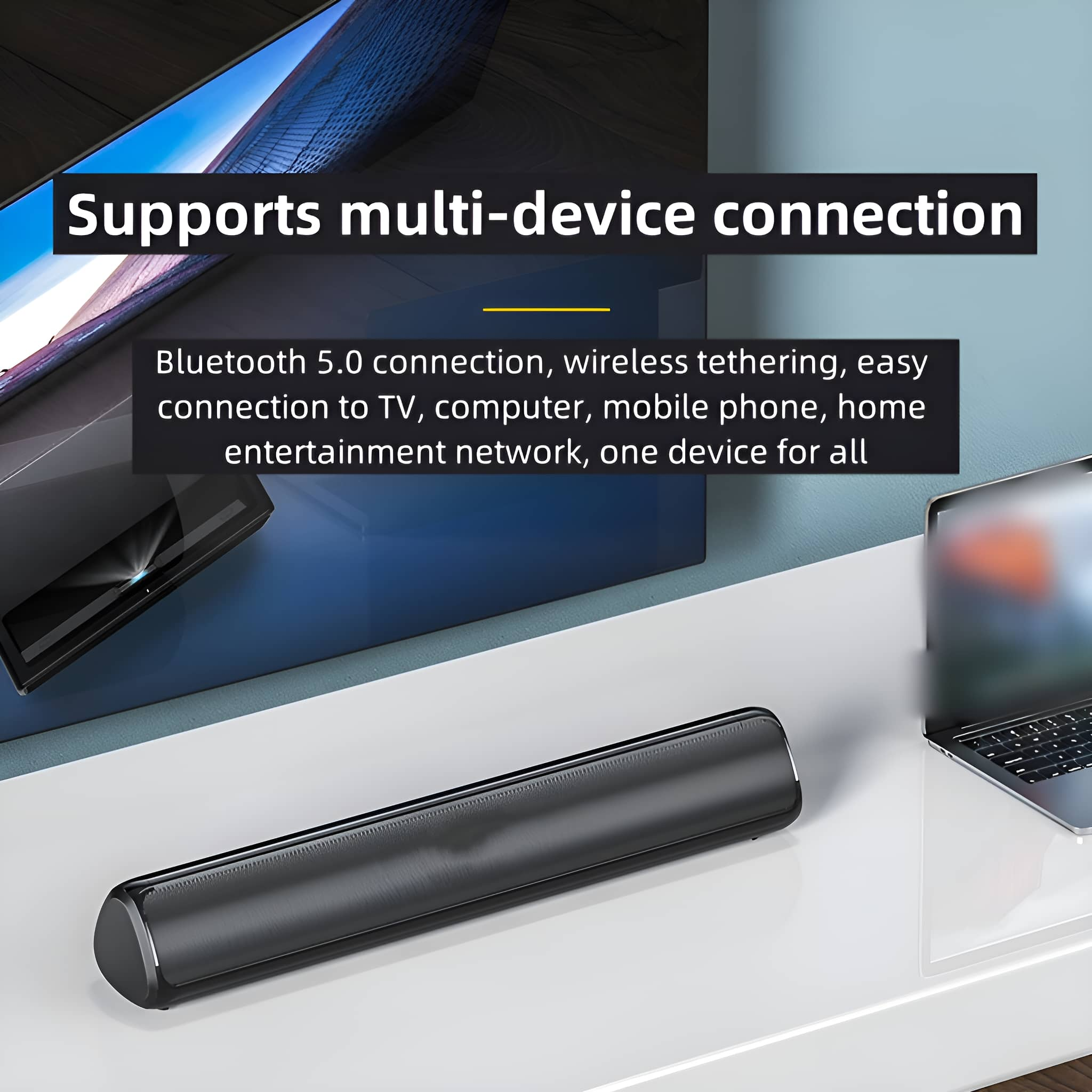 Schwarze Soundbar auf einem weißen Tisch. Dahinter befinden sich ein Fernseher und ein Laptop. Unterstützt Multi-Geräte-Verbindung.