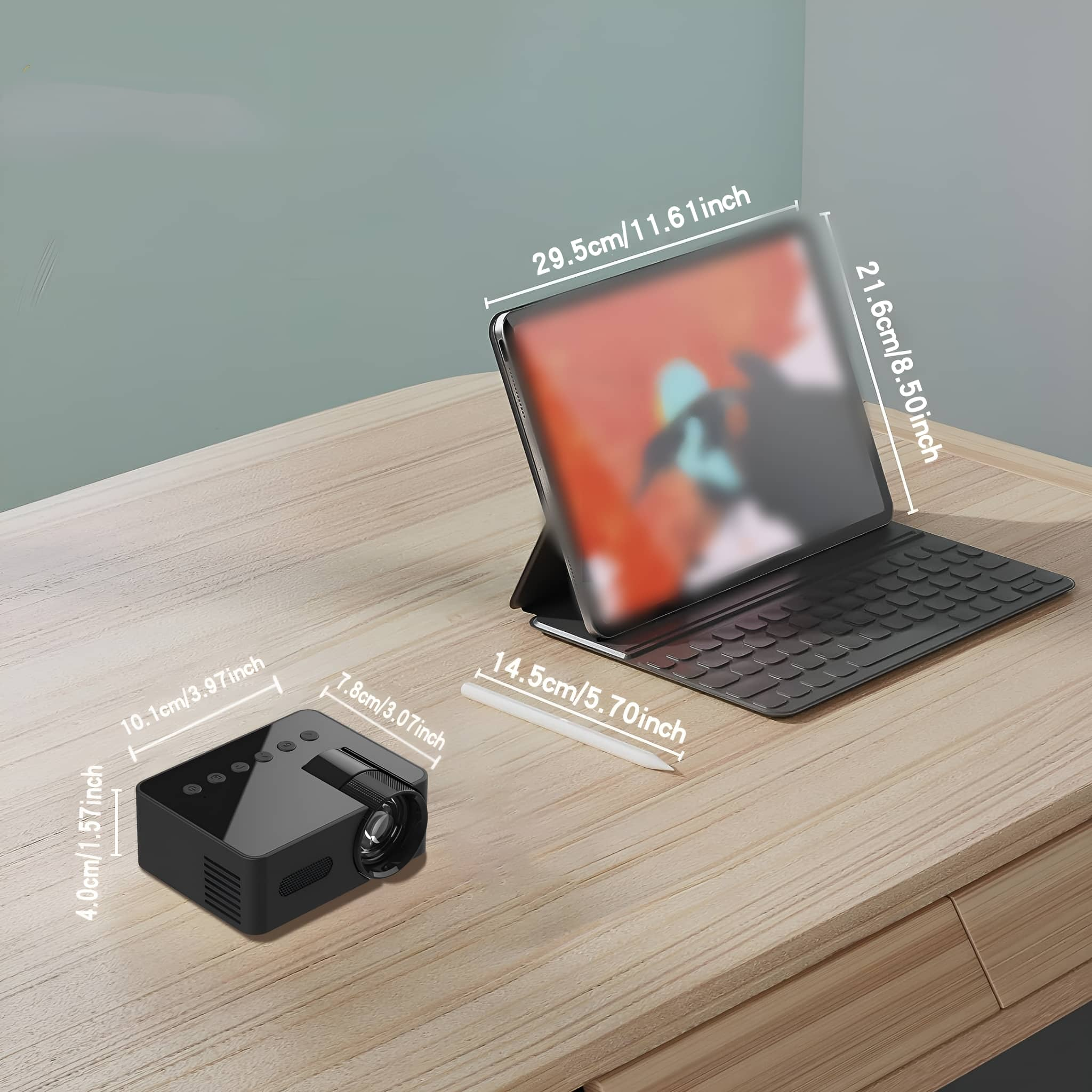 Schwarzer Projektor neben einem Tablet auf einem Holztisch, zeigt Bildschirmabmessungen in cm/Zoll.