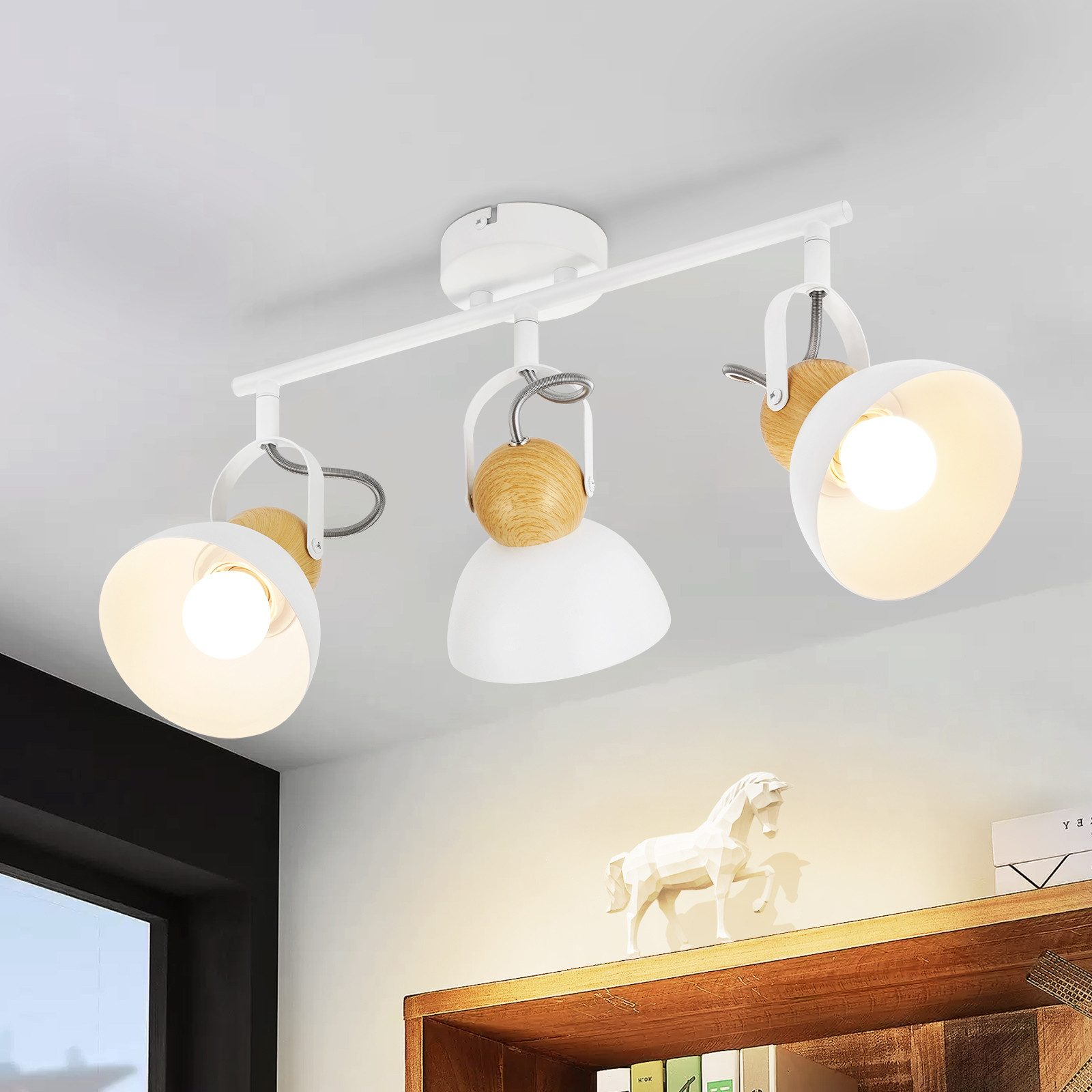 Faretti da soffitto bianchi con dettagli in legno e una mensola decorativa con una statuina di cavallo bianco.