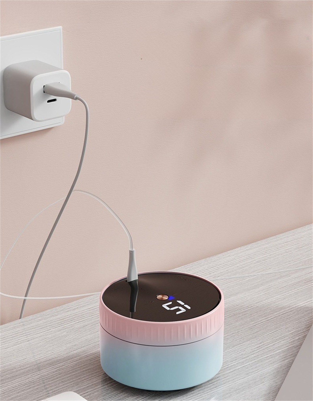 Eine Ladestation mit einem rosa-blauen Gerät, das an eine Steckdose angeschlossen ist.