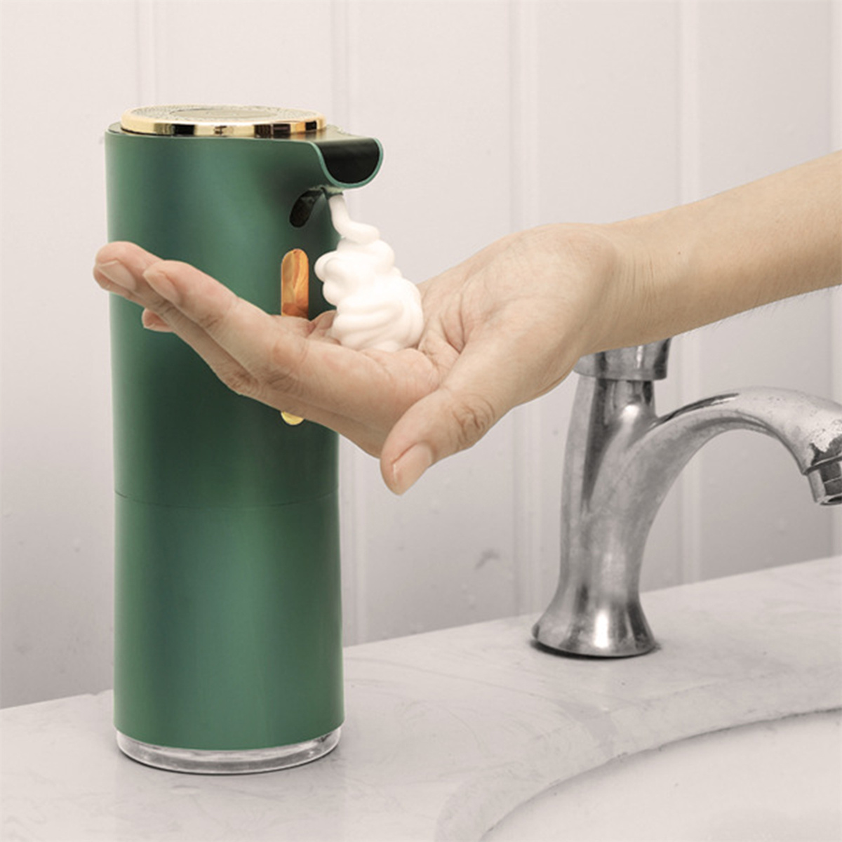 Ein grüner automatischer Seifenspender gibt Schaum in eine Hand ab, mit einer Chromarmatur im Hintergrund.