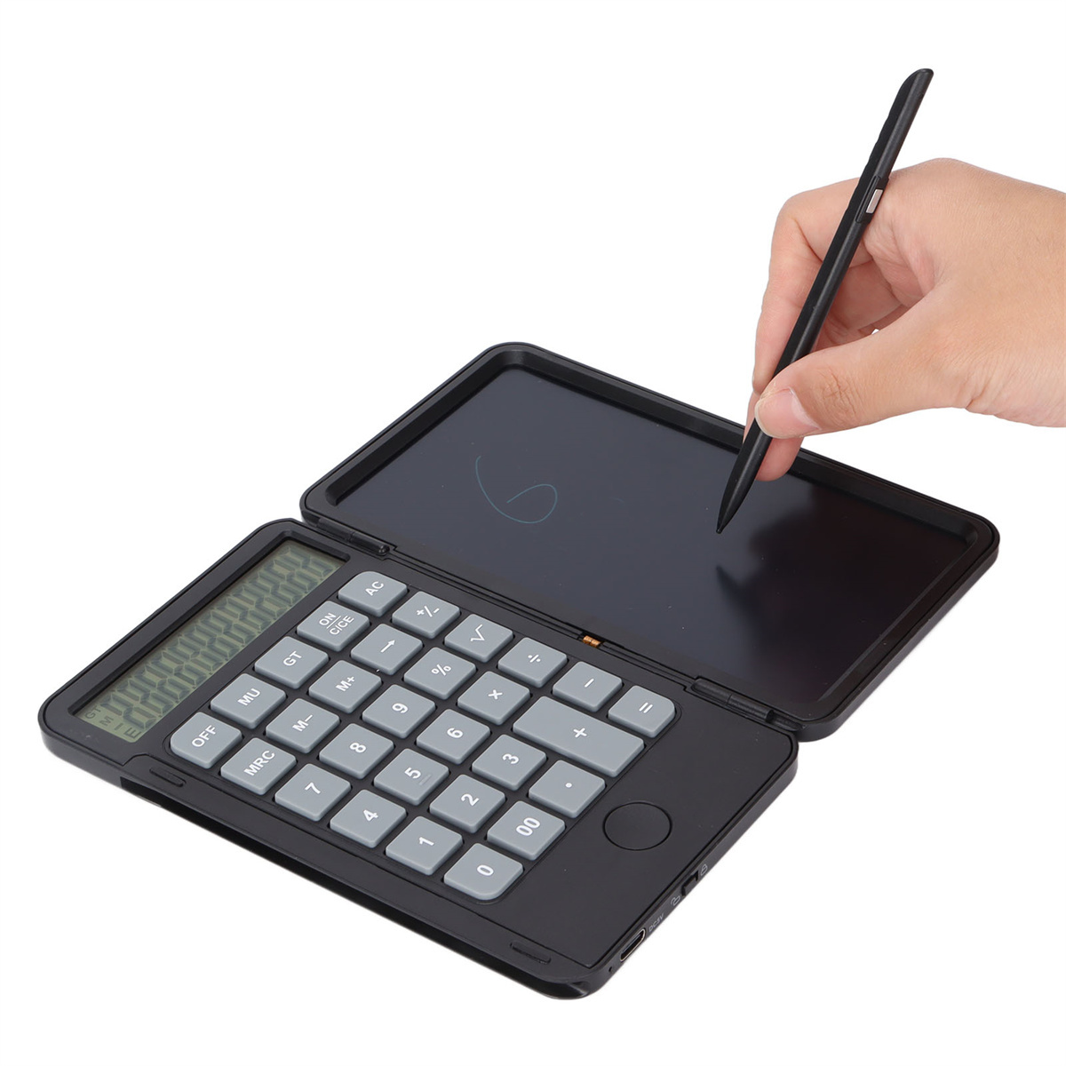 Schwarzer Taschenrechner mit Schreibblock. Eine Hand schreibt mit einem Stift auf dem Block.