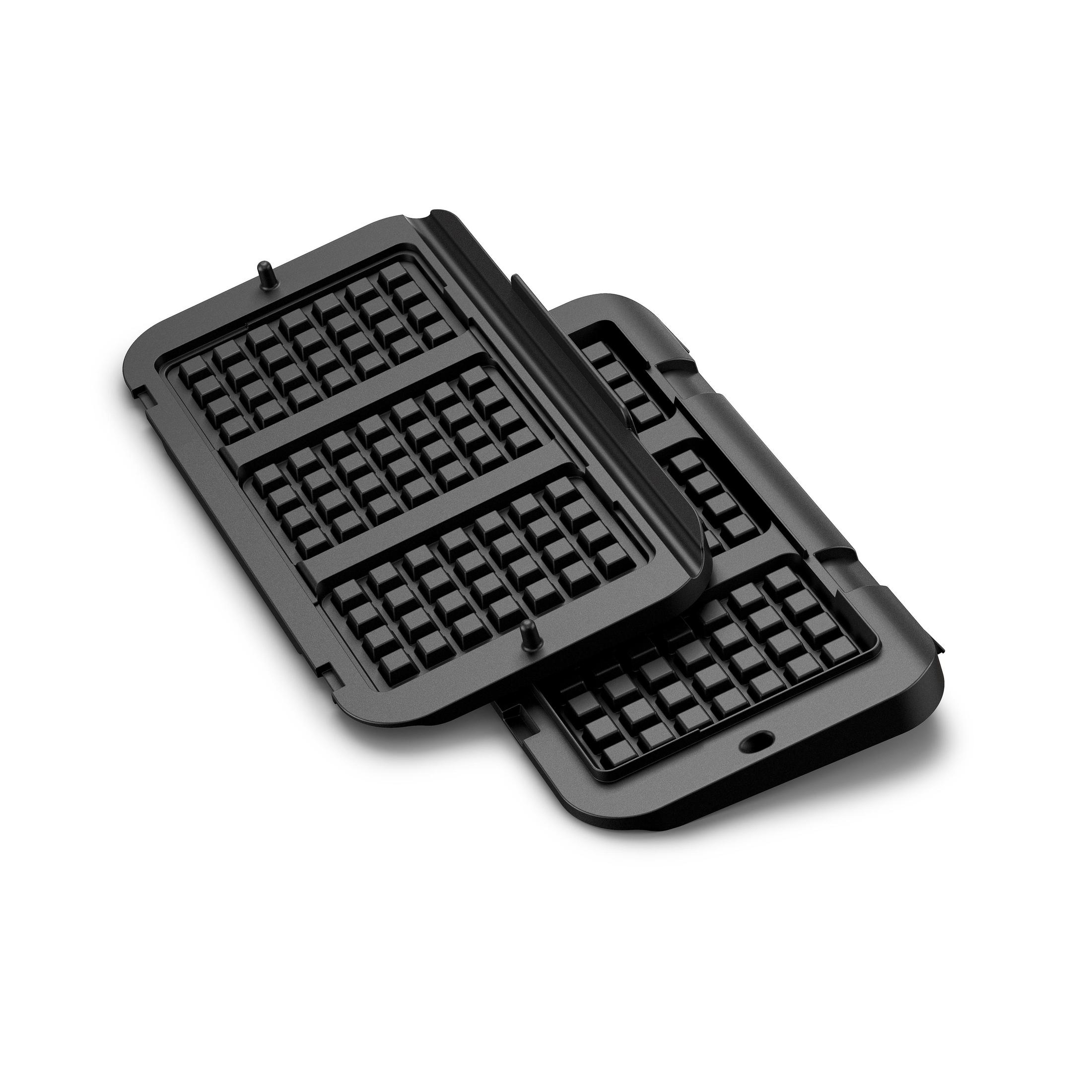 Zwei schwarze Waffeleisenplatten, angewinkelt auf einer weißen Oberfläche.