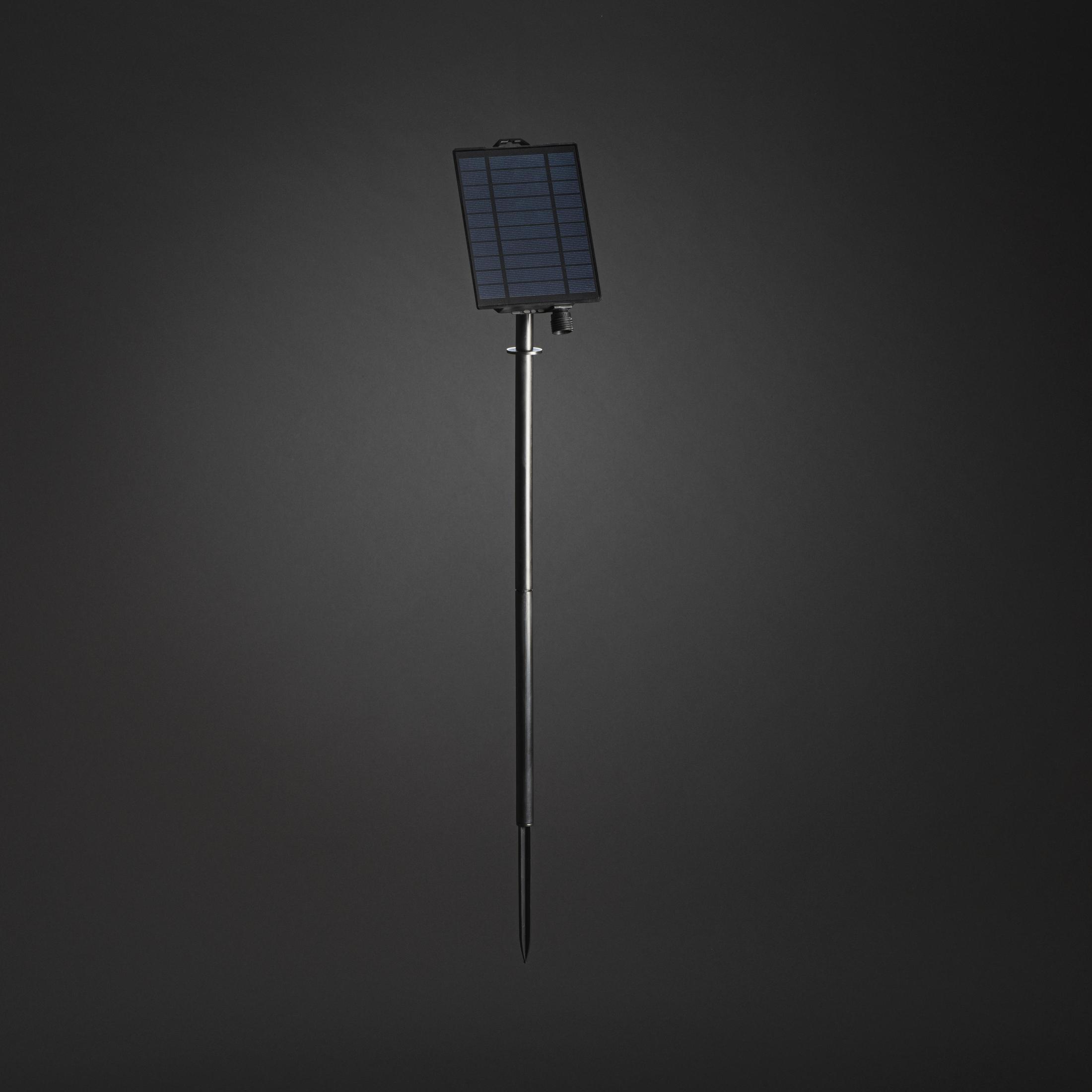 Solarpanel auf Ständer. Schwarzes Panel, silberne Stange, dunkler Hintergrund.