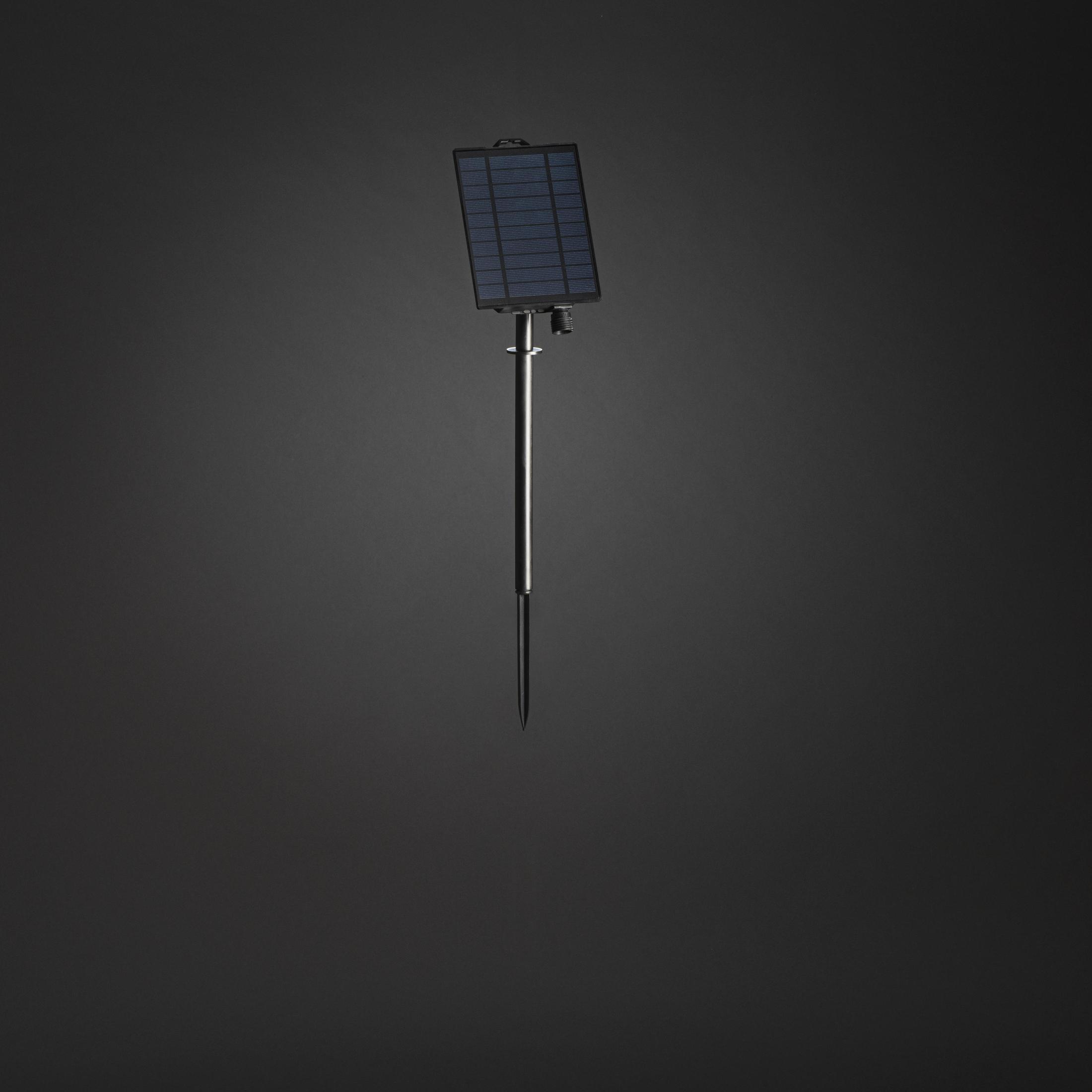 Ein kleines Solarpanel auf einer Metallstange vor einem dunkelgrauen Farbverlaufshintergrund.