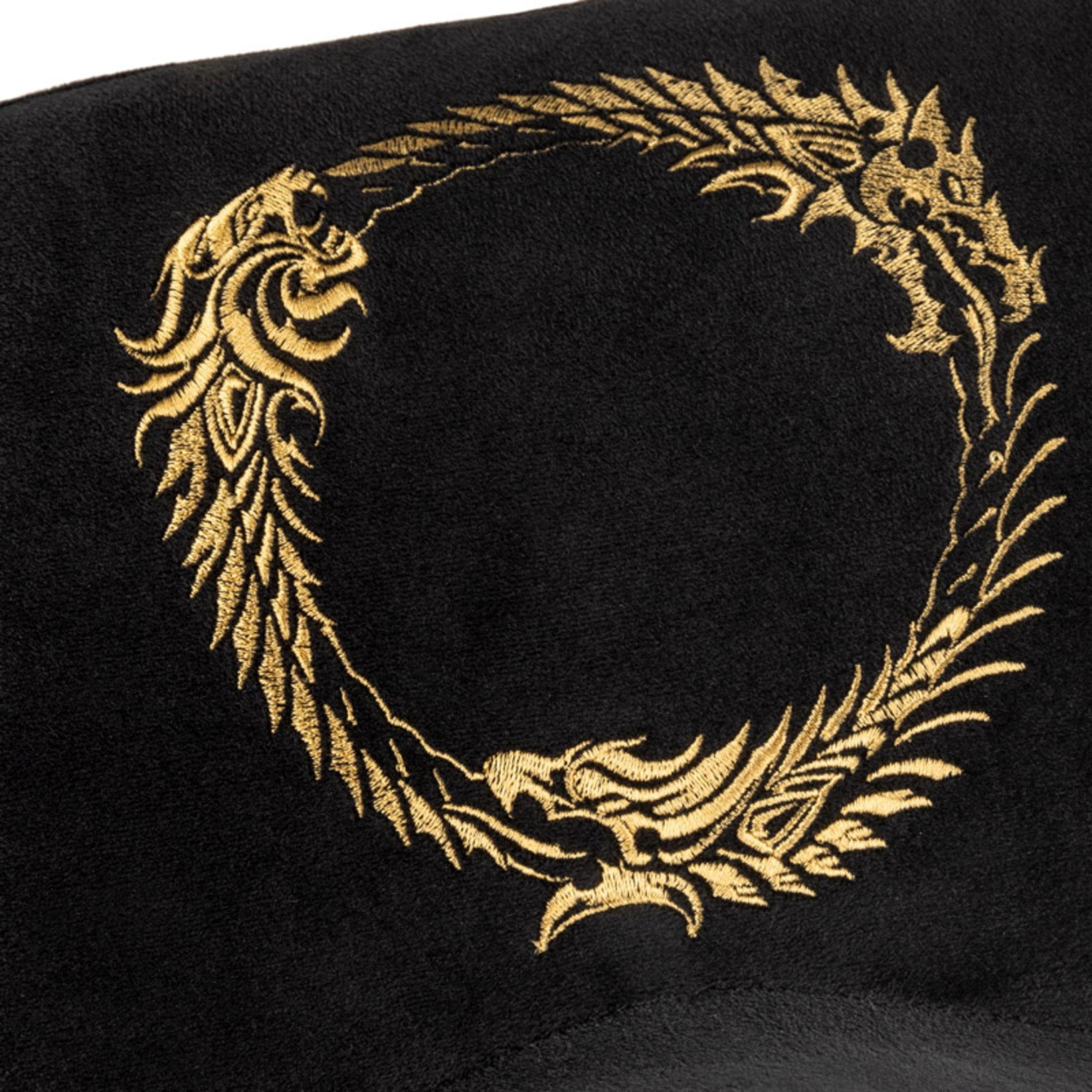 Schwarzes Kissen mit goldener Stickerei eines kreisförmigen Drachendesigns.