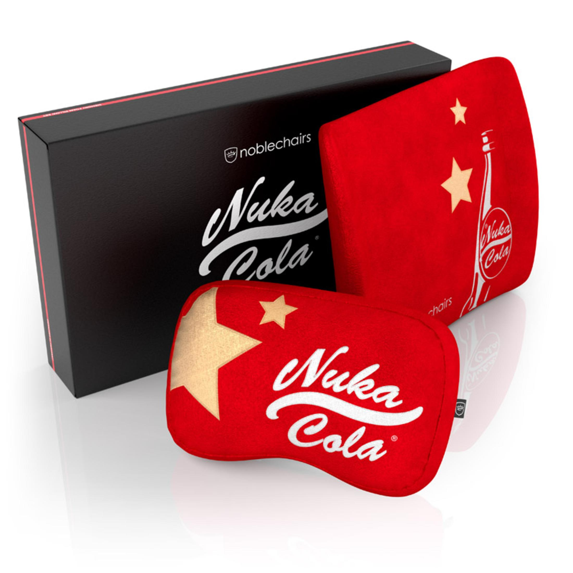 Zwei rote Nuka Cola Kissen und eine schwarze Box mit dem Nuka Cola Logo liegen auf einer weißen Oberfläche.