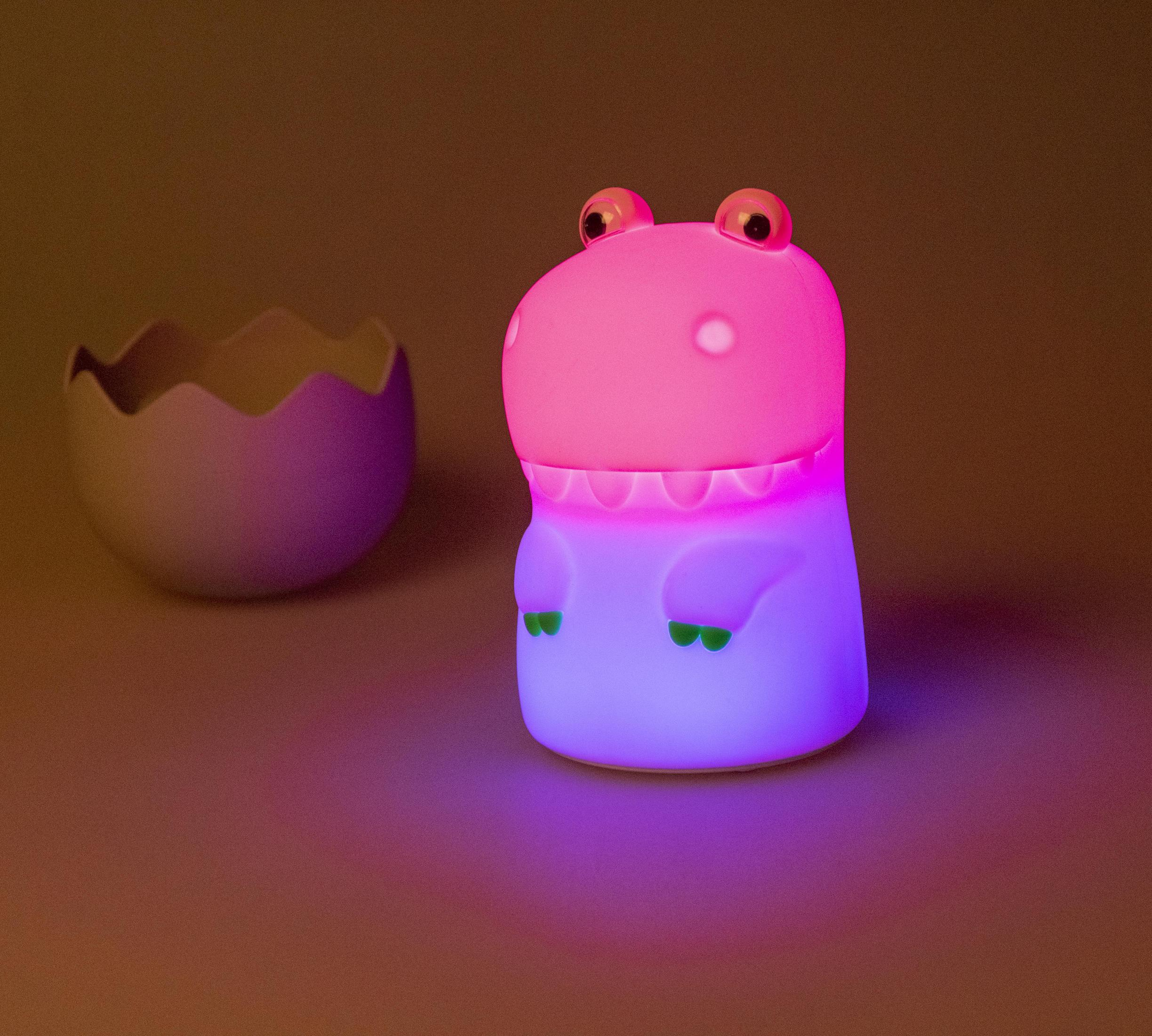 Pinke Dinosaurierlampe mit farbenfroher Beleuchtung und einem eiförmigen Objekt im Hintergrund.