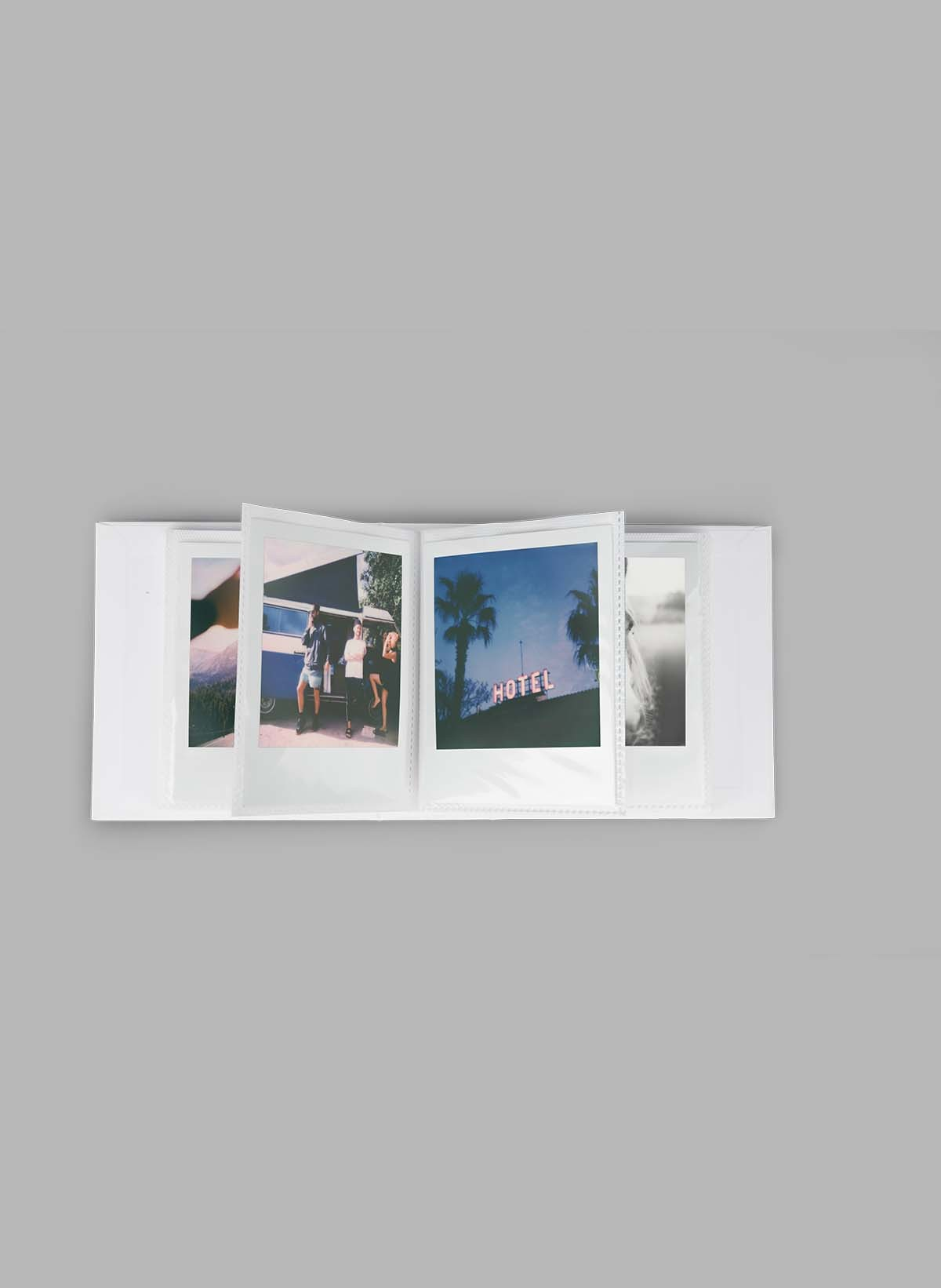 Fotoalbum offen mit mehreren Fotos von Personen und einem Hotelschild.