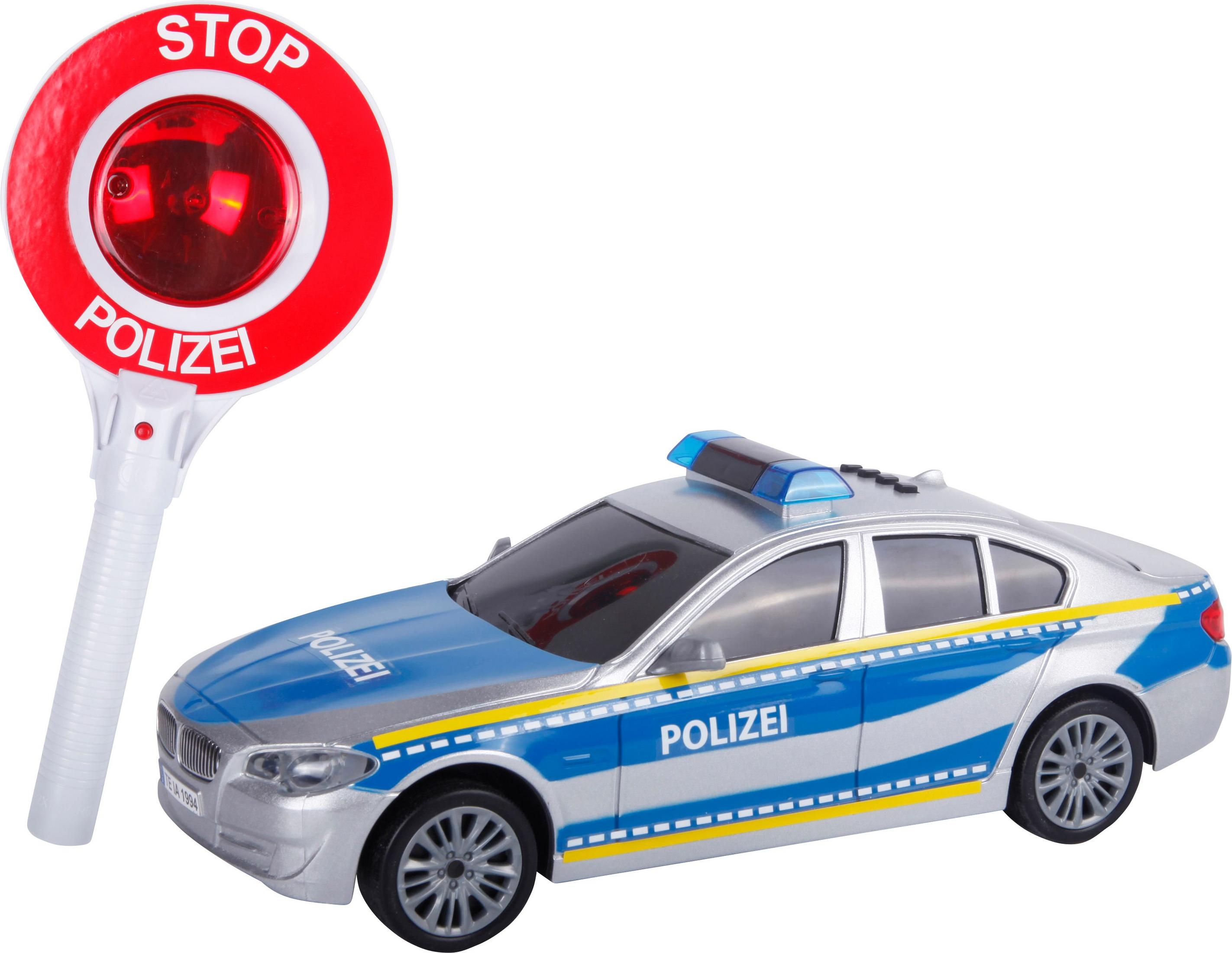 Spielzeug-Polizeiauto und Stoppschild. Blaues und silbernes Auto, rotes Stoppschild mit weißen Buchstaben.