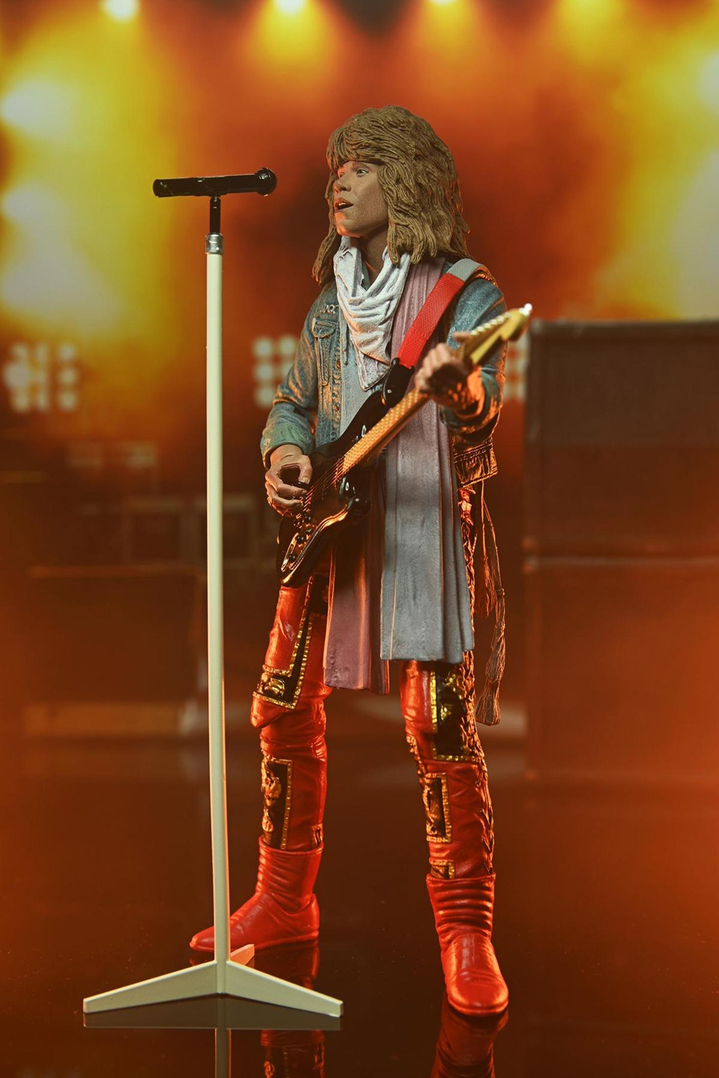 Eine Rock-Star-Figur mit einer Gitarre, die vor einer Bühne mit Lichtern steht.