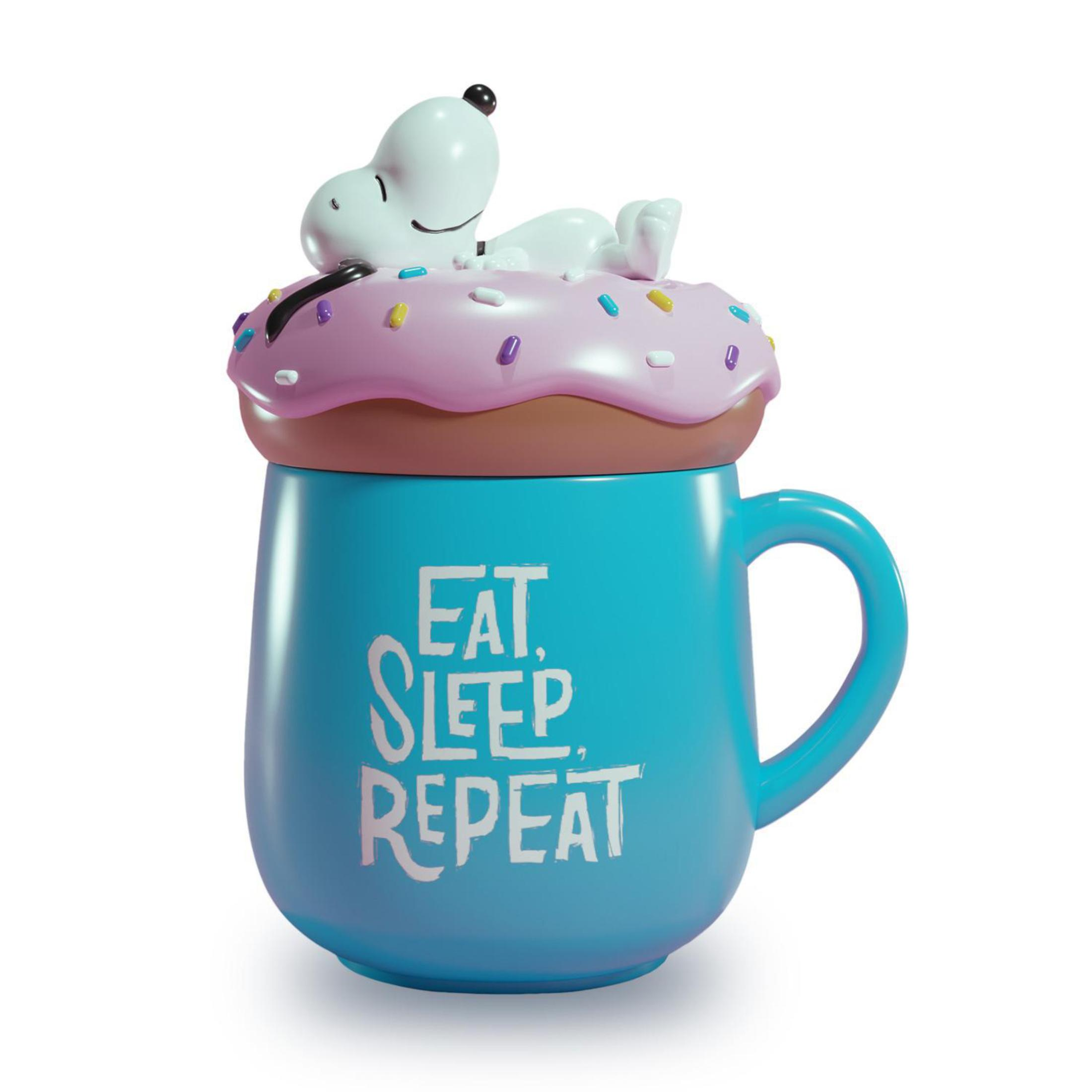 Blaue Tasse mit Snoopy auf Donut-Deckel, auf weißem Grund.