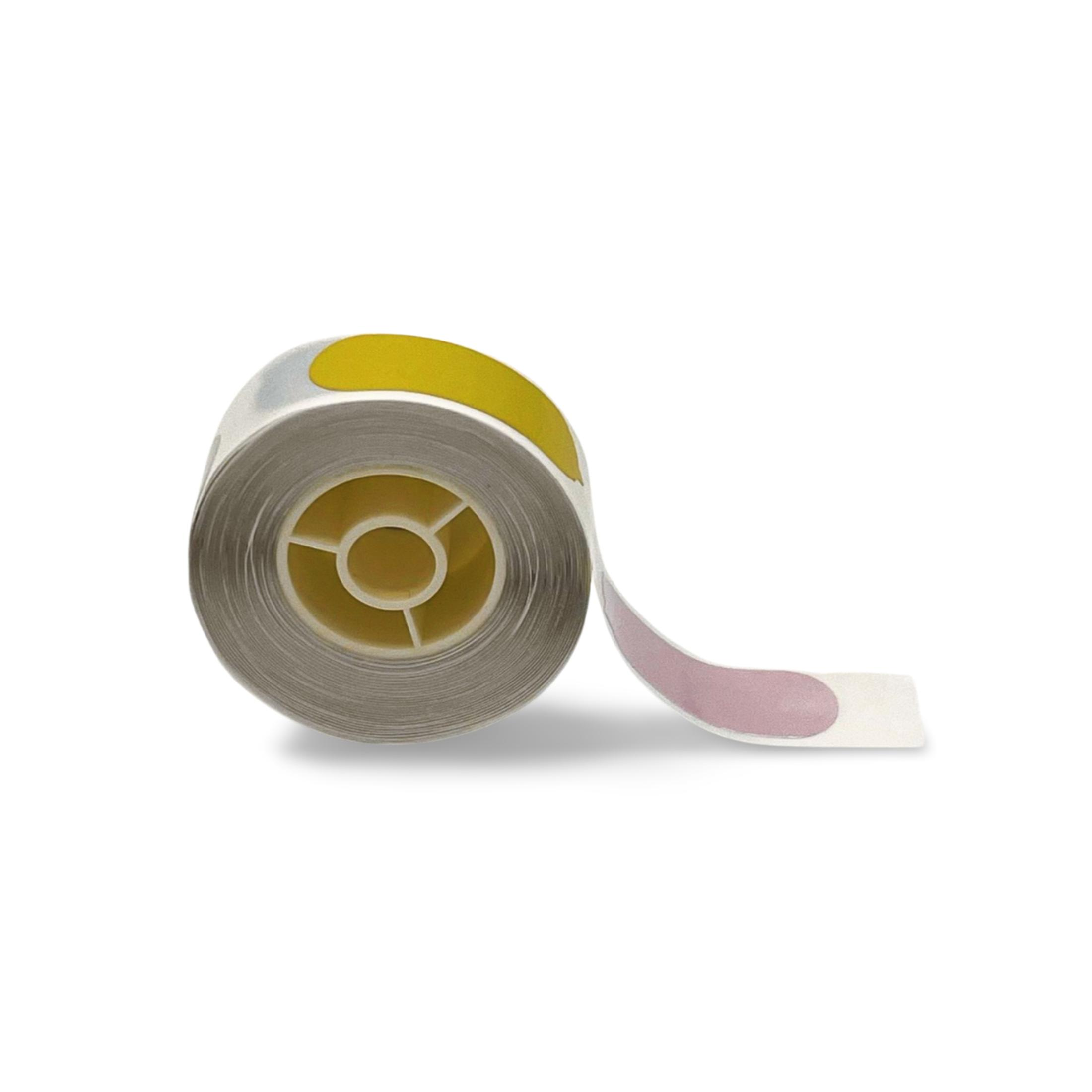 Eine Rolle Etiketten mit Gelb und Rosa auf einer weißen Oberfläche, die ein kreisförmiges Design zeigt.