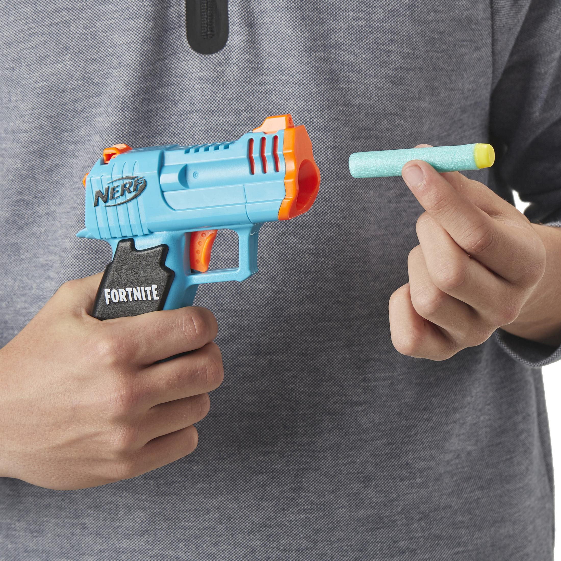 Eine Person hält eine blaue und orangefarbene Nerf-Pistole und einen gelben Dart. Die Pistole ist schwarz und orange.