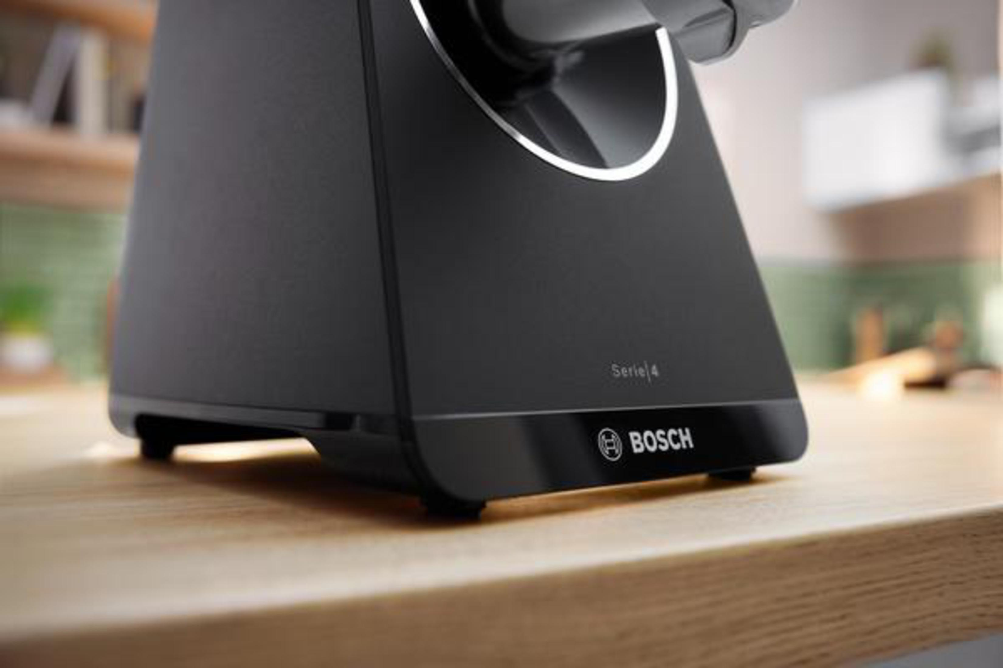 Czarny sprzęt Bosch Serii 4. Urządzenie stoi na drewnianej powierzchni. Słowo 'Bosch' znajduje się pod produktem.