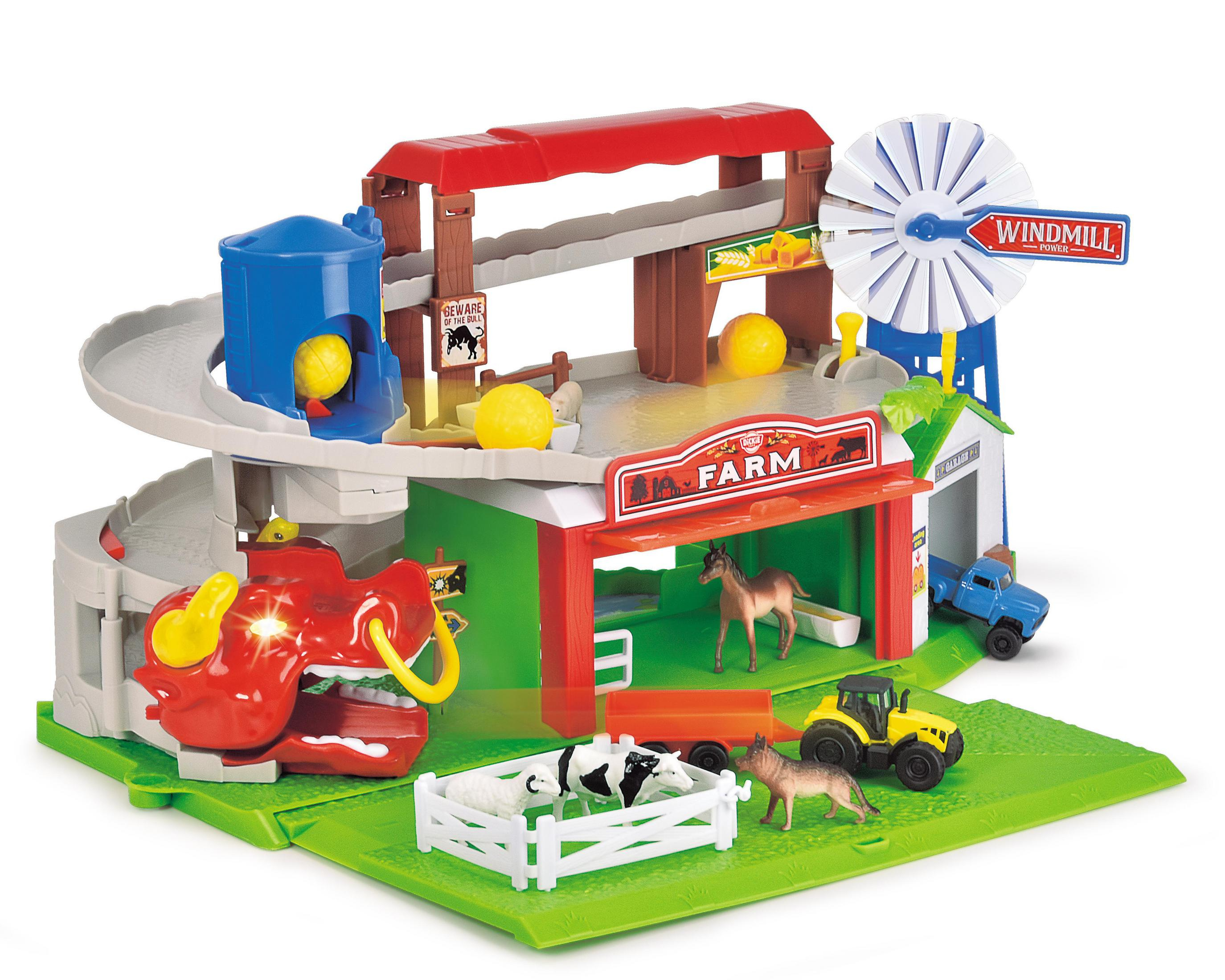 Ein Spielzeug-Bauernhof mit Windmühle, roter Scheune, Tieren und blauem LKW auf grüner Basis.