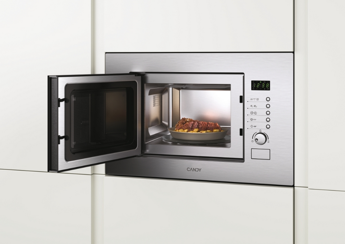 Een magnetron met open deur, een bord met eten en bedieningsknoppen.