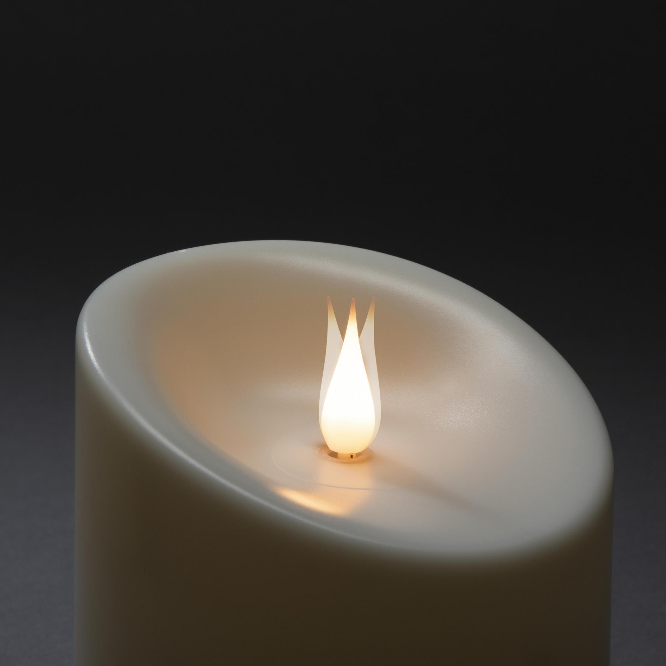 Eine cremefarbene Kerze mit einer flackernden, beleuchteten Flamme, vor dunklem Hintergrund.