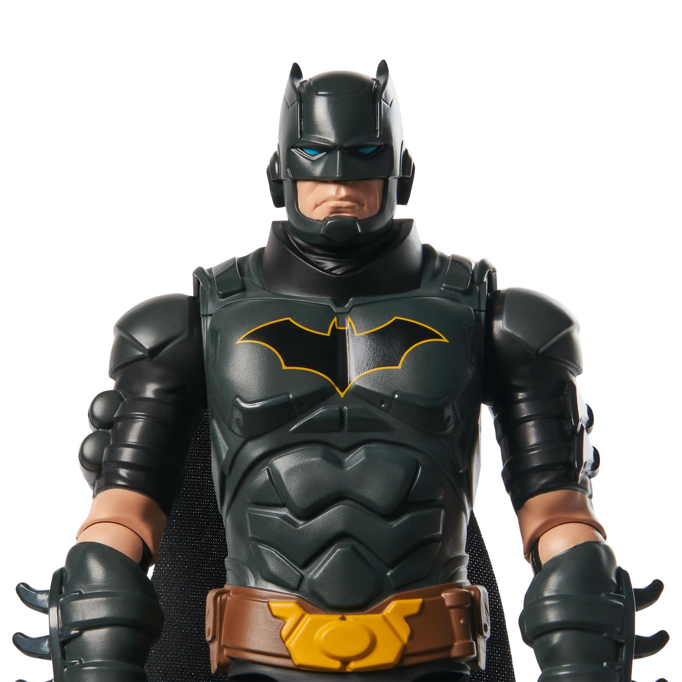 Batman-Actionfigur. Dunkelgraue und schwarze Rüstung. Gelbes Fledermaussymbol. Weißer Hintergrund.