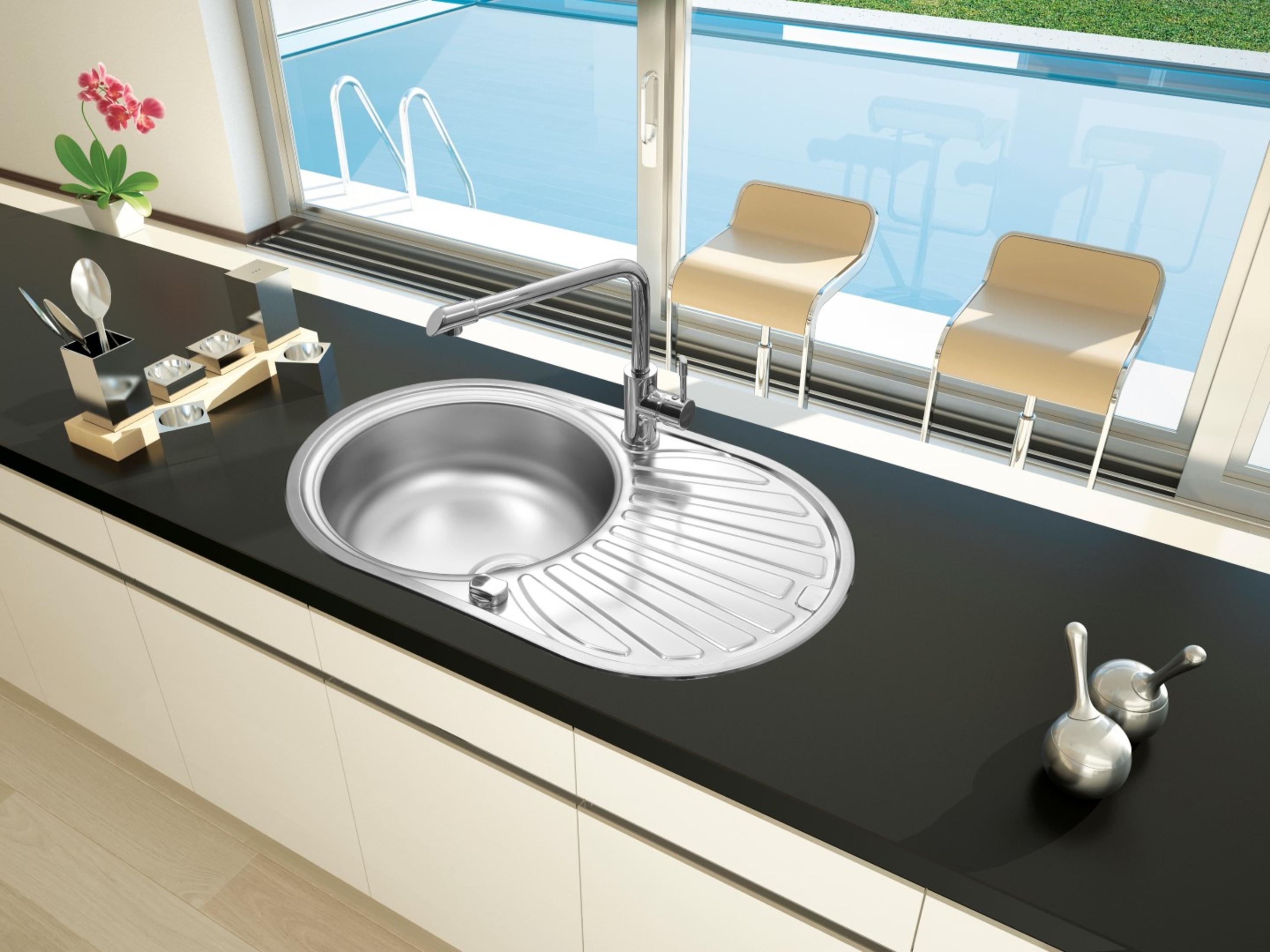 Ein Edelstahlspülbecken mit rundem Becken und Abtropffläche, mit Wasserhahn.