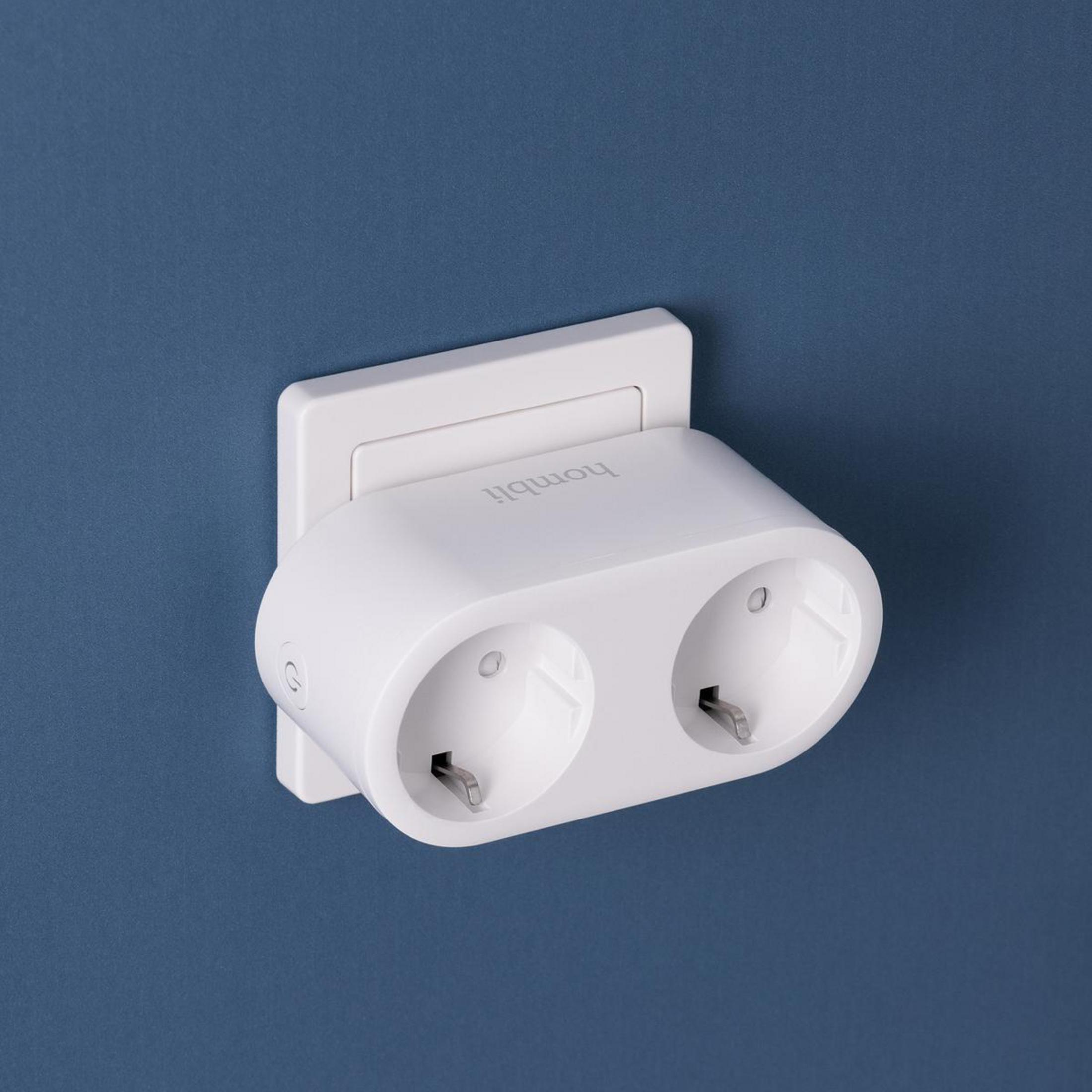 Ein weißer Smart Plug, installiert in einer blauen Wand, mit zwei Steckdosen.