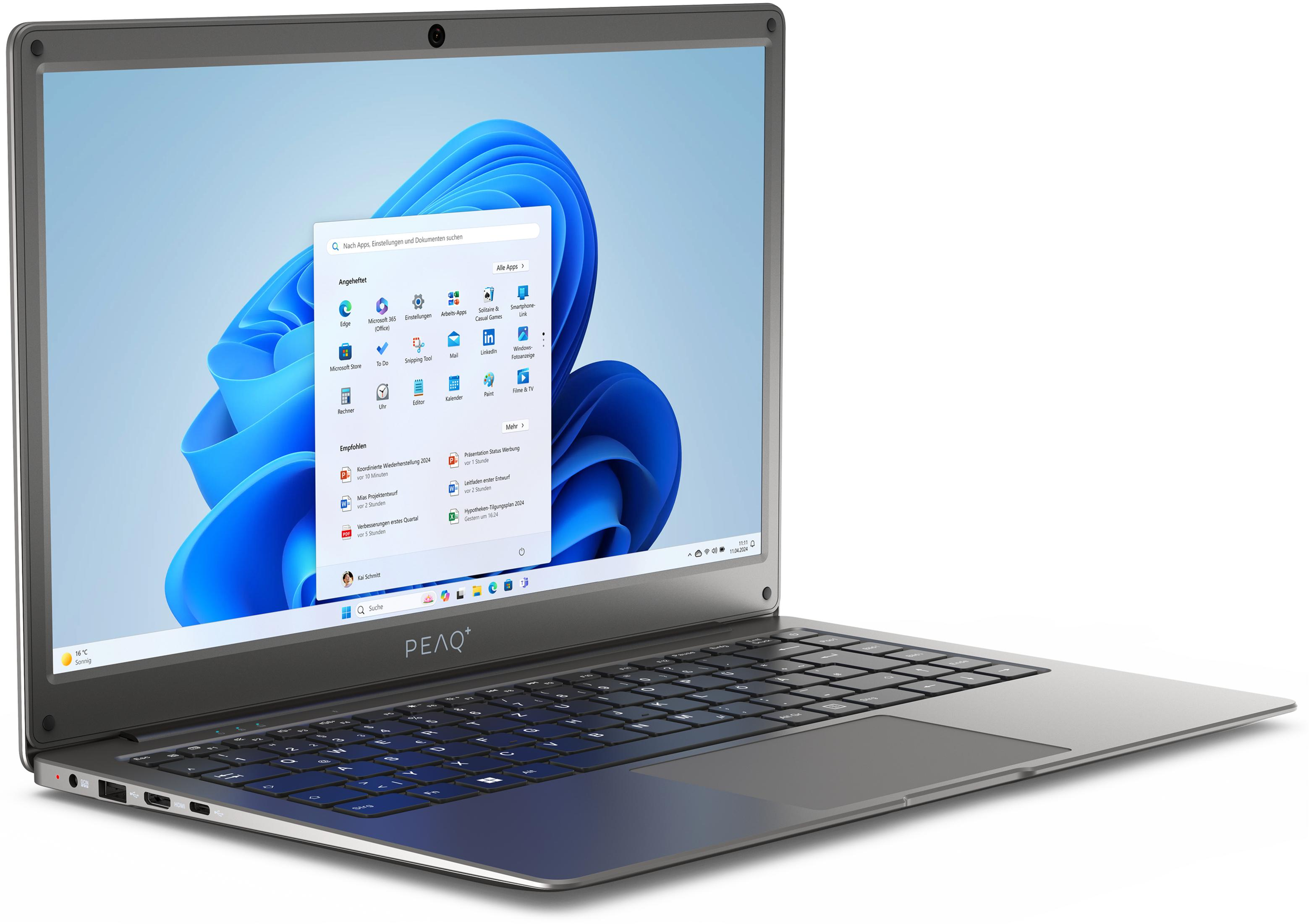 Silberner Laptop, geöffnet auf einem Tisch, zeigt Windows 11-Oberfläche mit Apps.