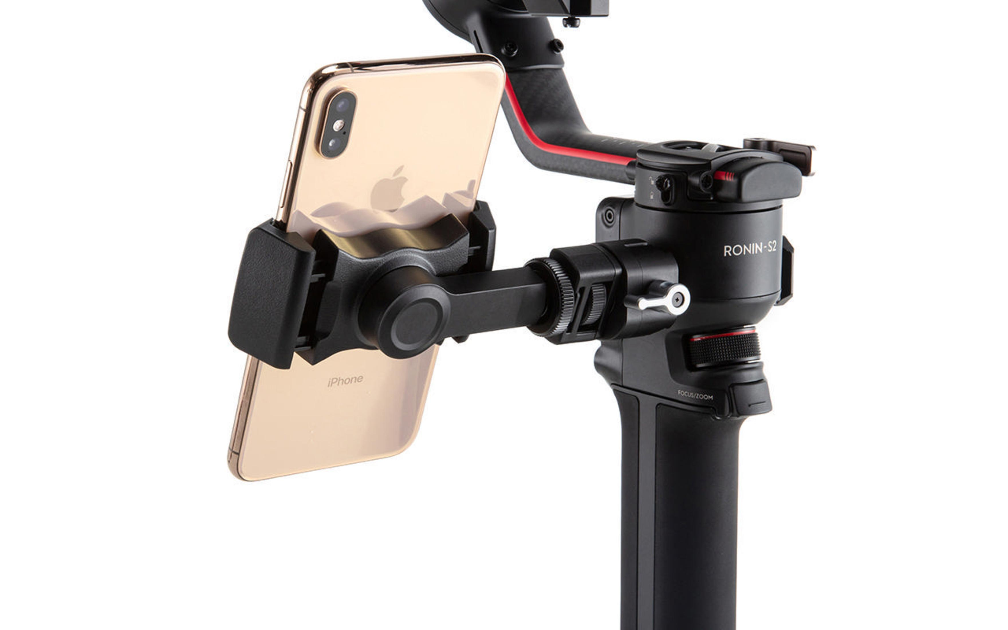 Uno stabilizzatore per fotocamera tiene in mano un iPhone d'oro. Lo stabilizzatore è nero e ha accenti rossi e un'impugnatura.