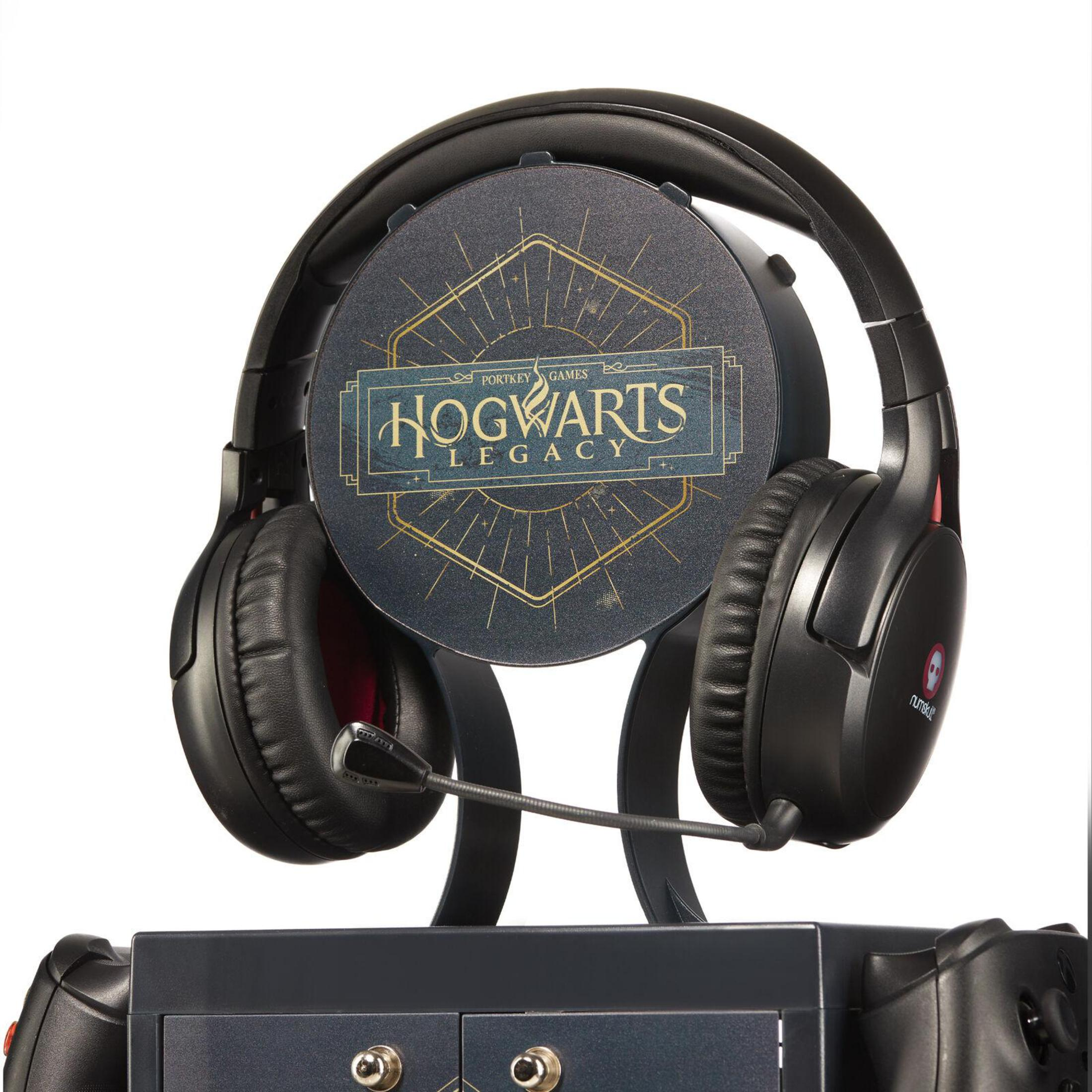 Schwarzes Gaming-Headset auf einem Ständer mit 'Hogwarts Legacy'-Logo, mit Controllern an der Basis.
