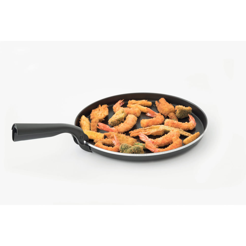 Patelnia wypełniona smażonymi potrawami na białym tle, widok z kąta.