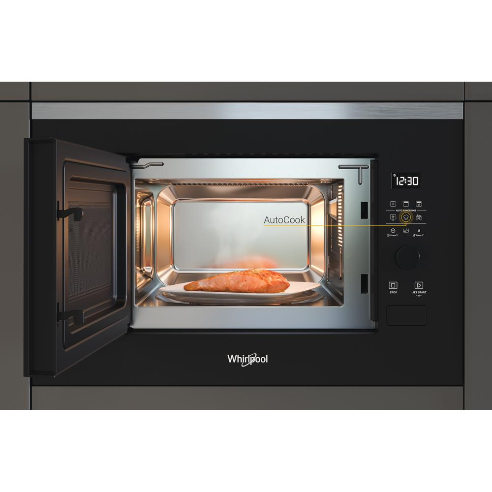 Microwave oven interior with food on a plate. Door open. Digital display shows time.