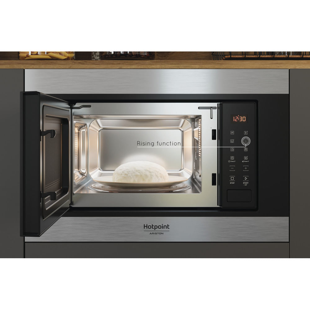 Interno del forno a microonde con piatto e cibo, porta aperta.