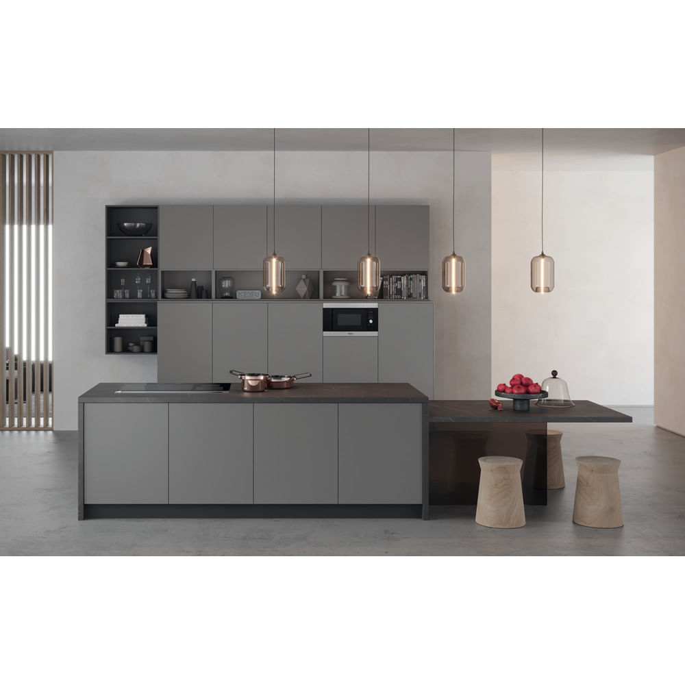 Cucina moderna con mobili grigi, isola e forno a microonde. Un tavolo ha degli sgabelli.