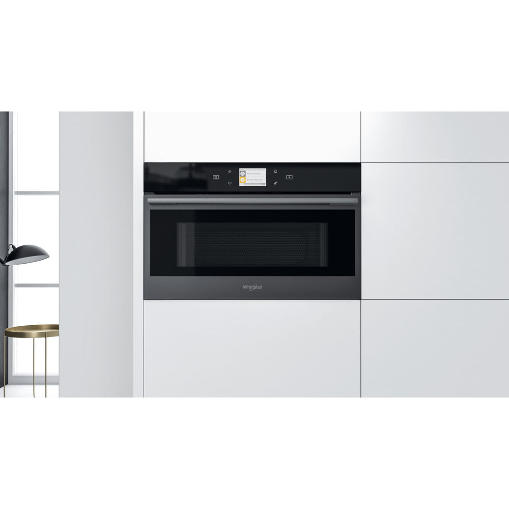 Forno a microonde nero con touchscreen, installato in un mobile bianco, con logo Whirlpool.