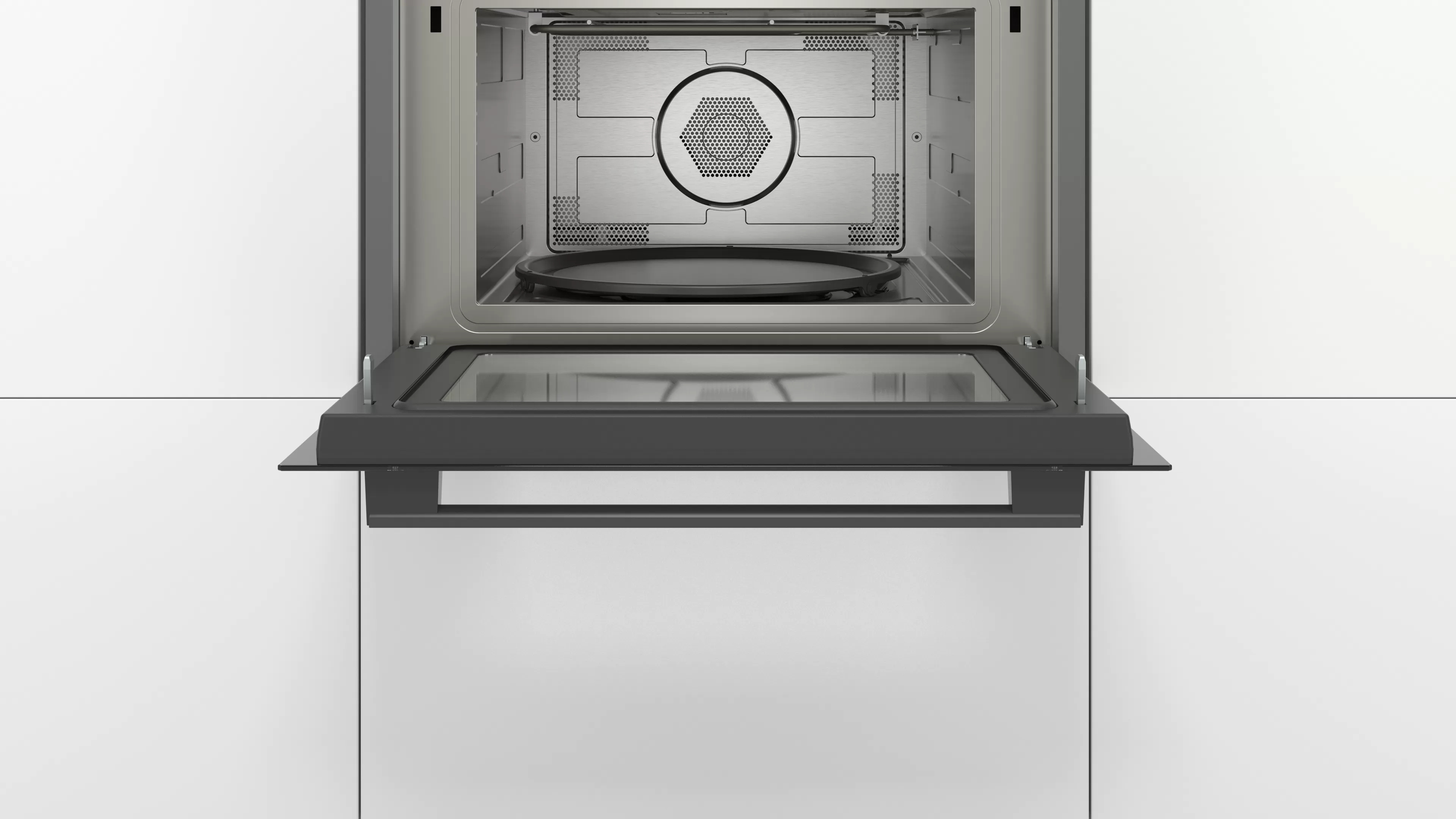 Een magnetrondeur is open, waardoor de binnenkant van de oven zichtbaar is. Het merk is Bosch.