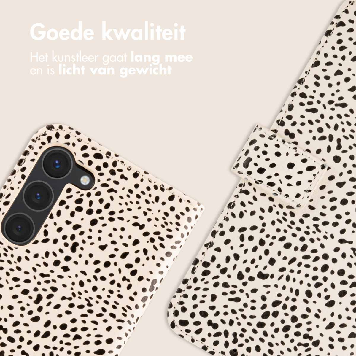 Coque de téléphone, blanche à pois noirs. Étui ouvert et la caméra du téléphone est visible en haut à gauche.