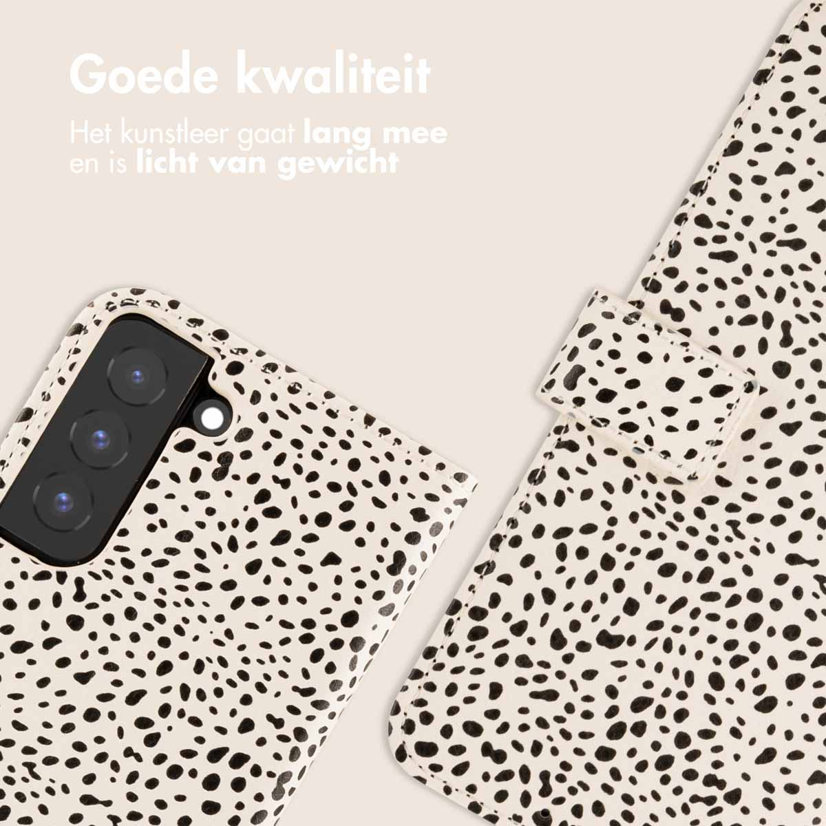 Coque de téléphone, blanche à pois noirs. Étui ouvert, caméra en haut à gauche, téléphone visible.