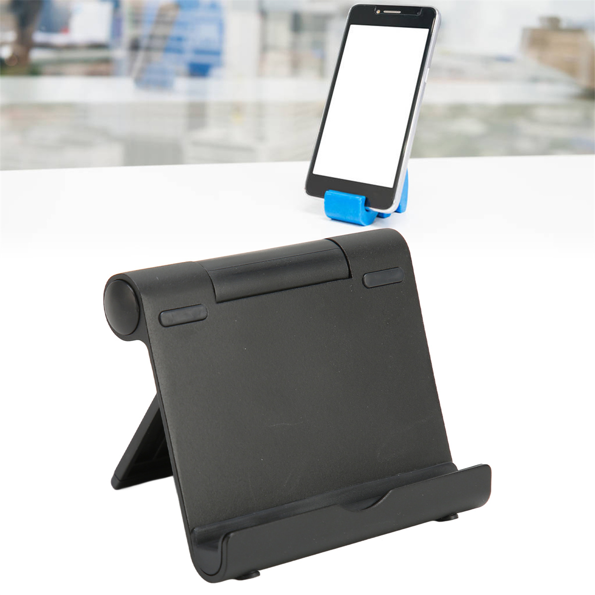 Schwarzer Tablet-Ständer, der ein Smartphone mit weißem Bildschirm hält. Der Ständer ist abgewinkelt.