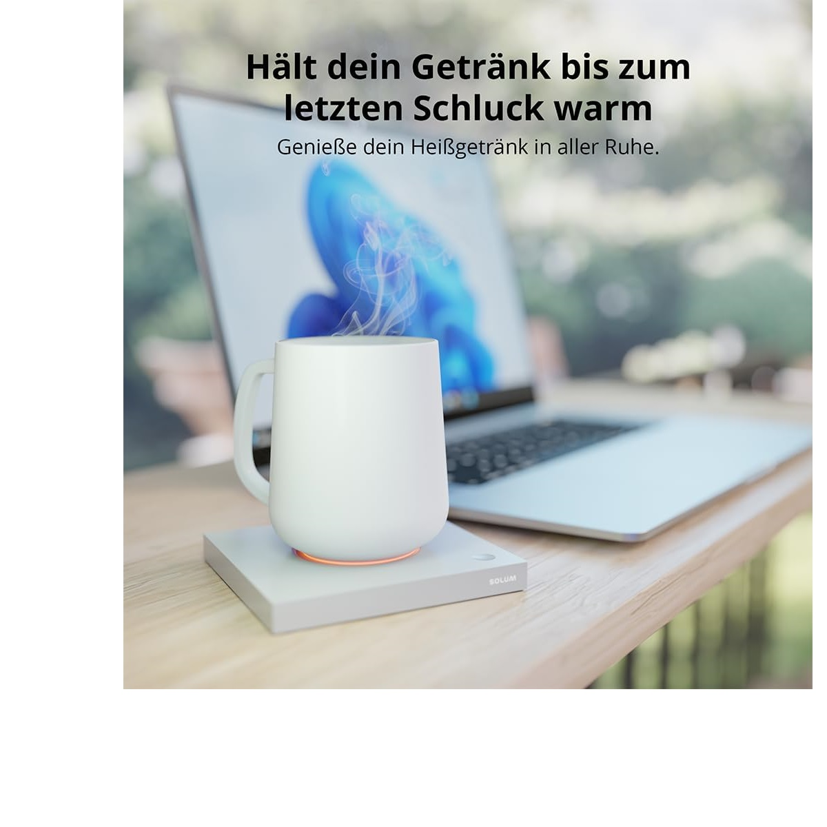 Ein weißer Becher auf einer Heizbasis, mit aufsteigendem Dampf, vor einem Laptop.