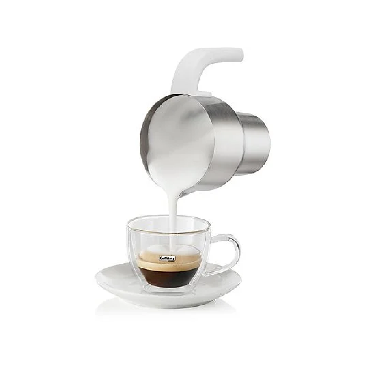 Milch wird in eine Glastasse Espresso auf einer weißen Untertasse gegossen.