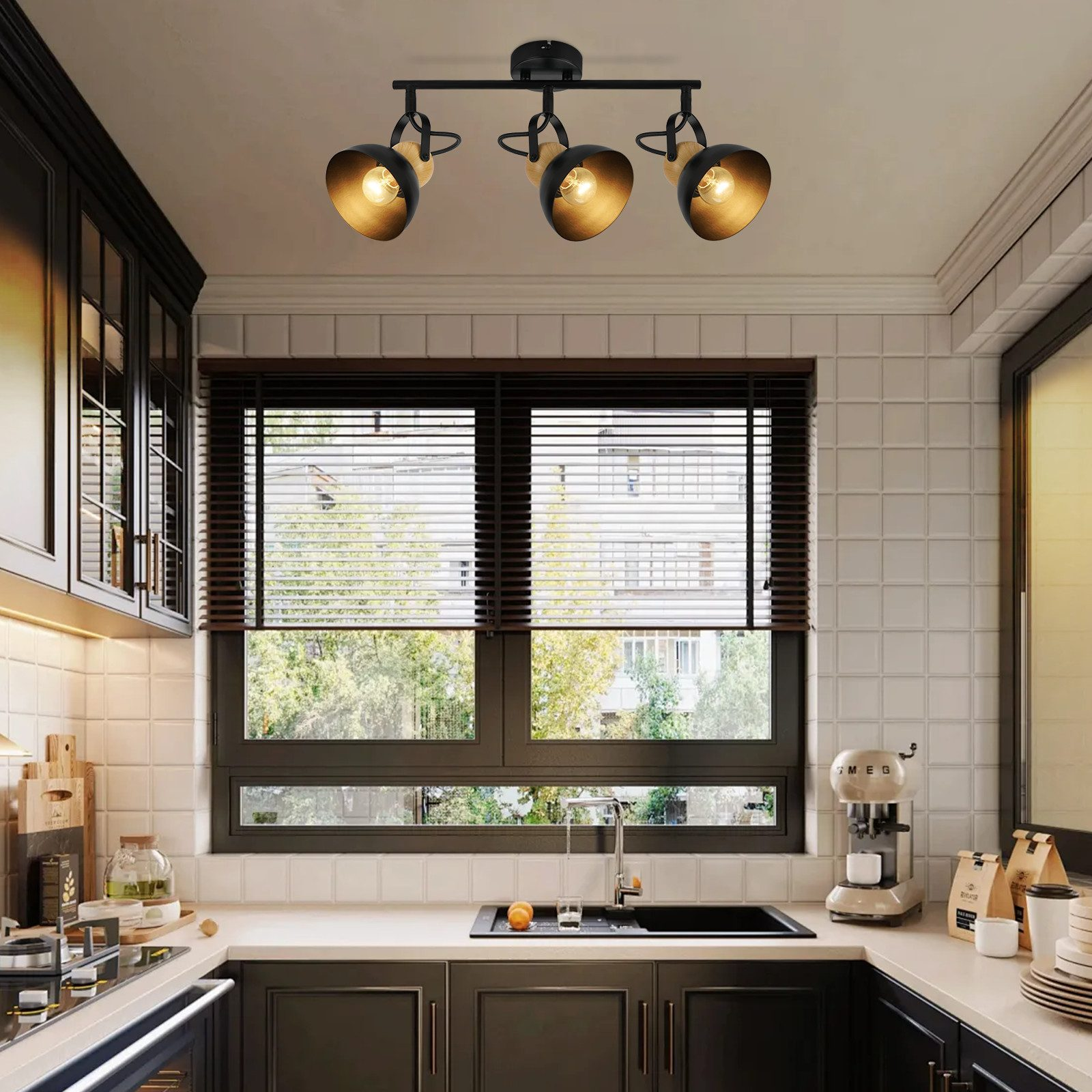 Scena w kuchni. Trzy złote reflektory, szafki, okno i zlew.