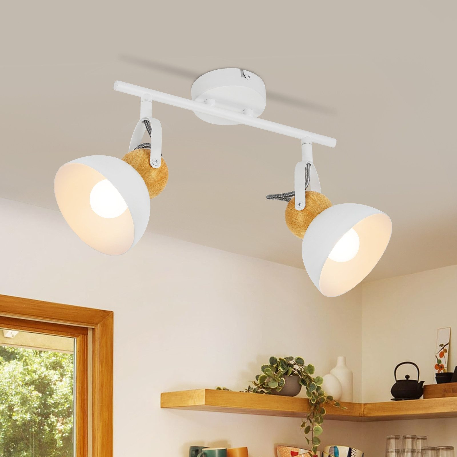 Due faretti bianchi su una barra bianca, montati a soffitto. Presenti accenti in legno.