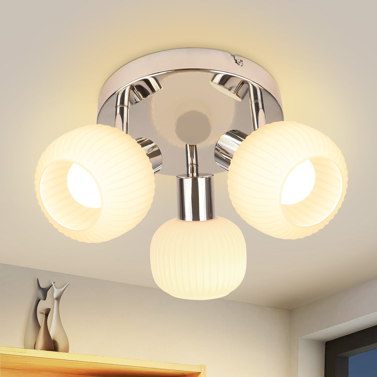 Plafoniera con tre lampade. Le lampade hanno un design a globo smerigliato.