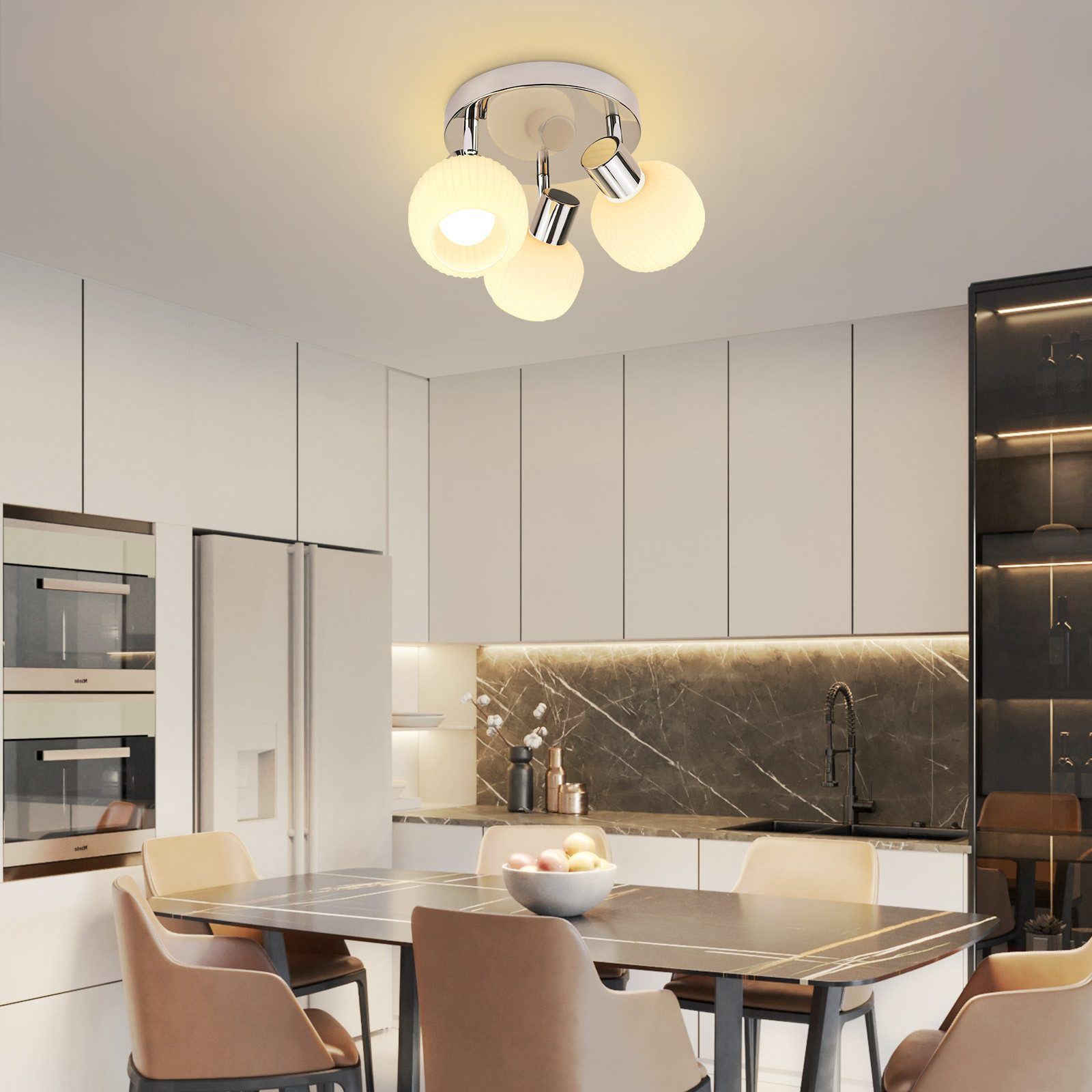 Lampada da soffitto con quattro paralumi sferici in vetro sopra un tavolo da pranzo.