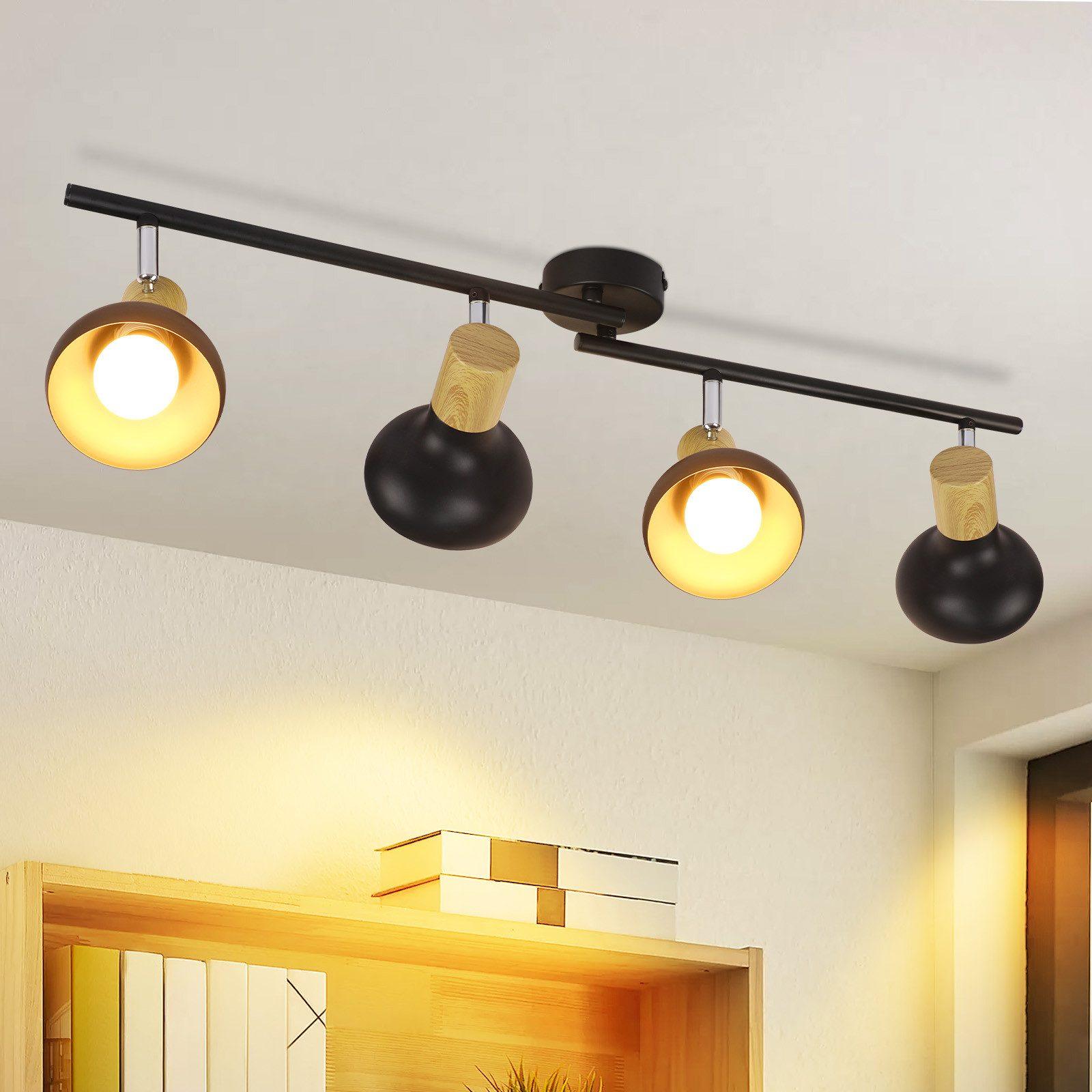 Soffitto con quattro faretti neri con accenti in legno, che illuminano una libreria sottostante.