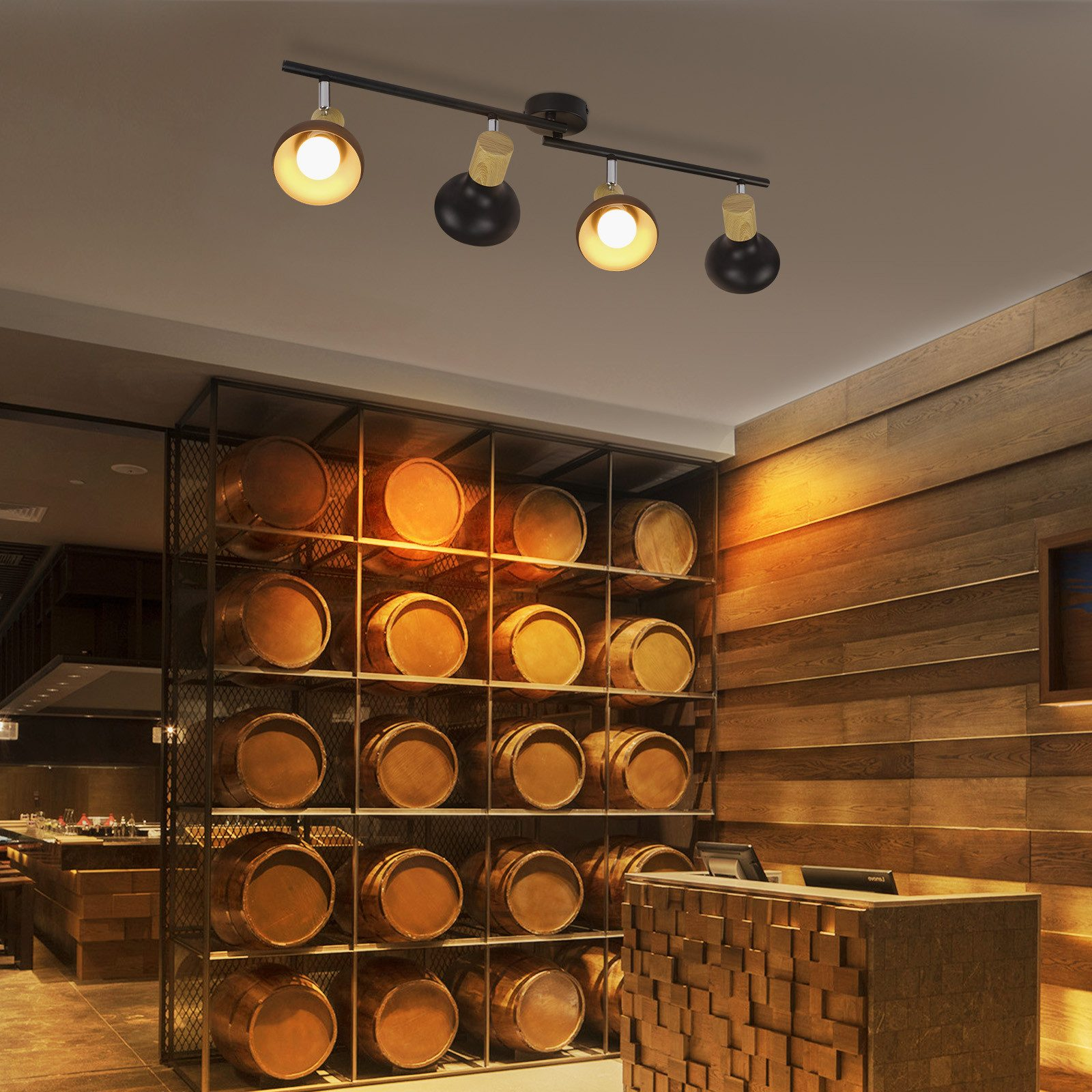 Luci sul soffitto. Sotto, una mensola con botti e un bancone di legno.