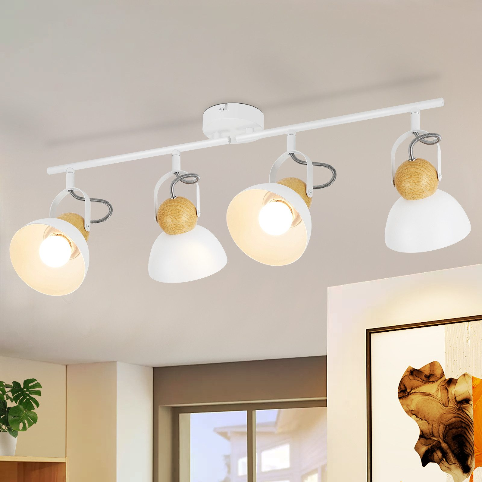 Illuminazione a binario bianca con quattro faretti regolabili su un soffitto.