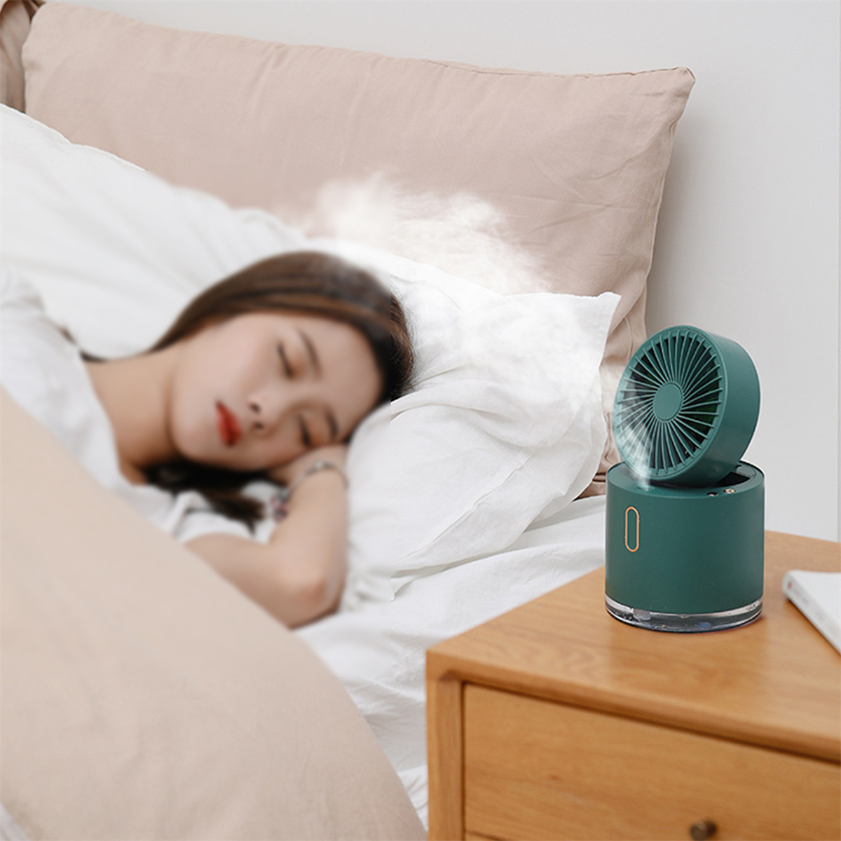 Frau schläft in der Nähe eines kleinen Ventilators, der Nebel erzeugt, auf einem Nachttisch.