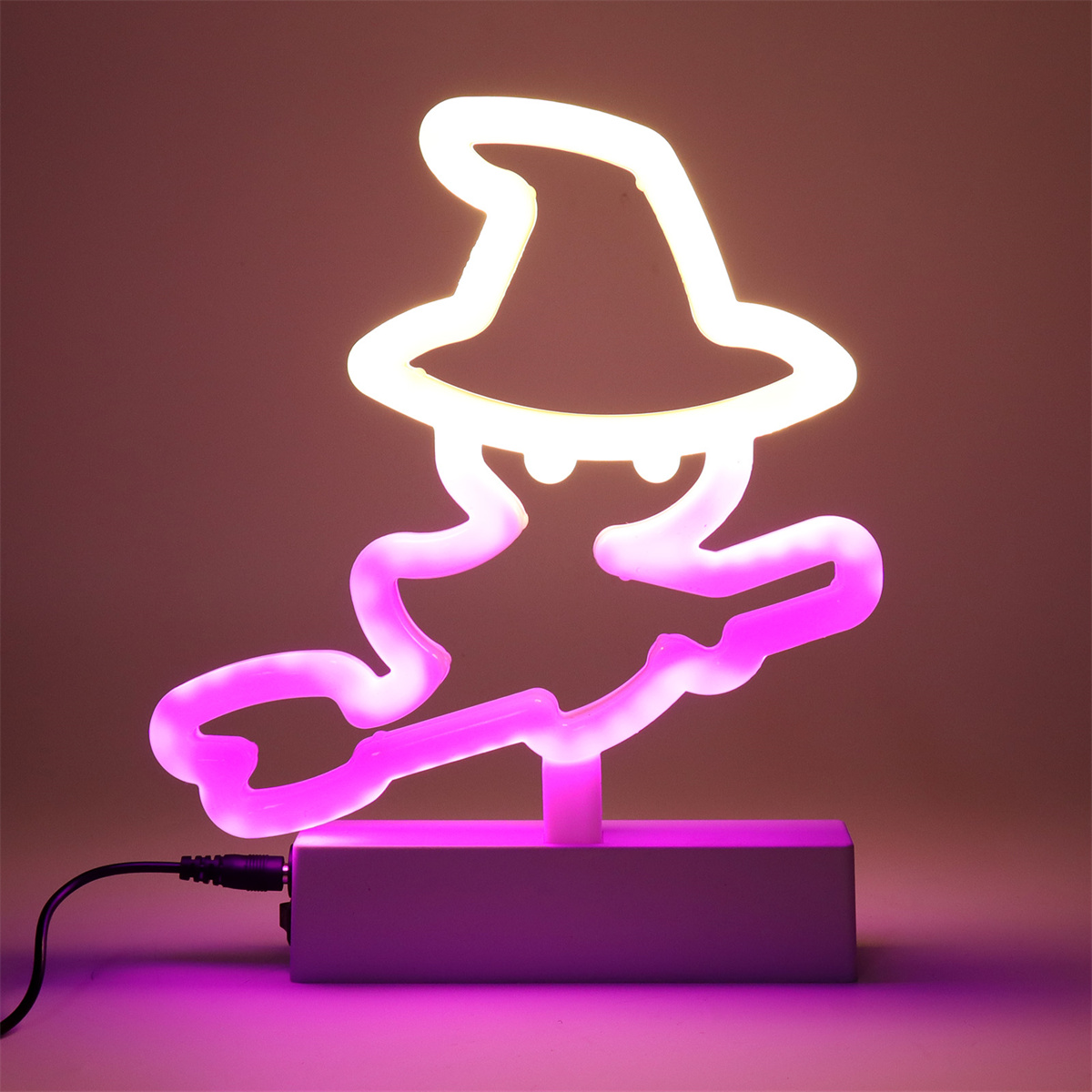 Neon-Hexenkontur auf pinkfarbener Basis, leuchtend weiß und pink, vor pinkfarbenem Hintergrund.